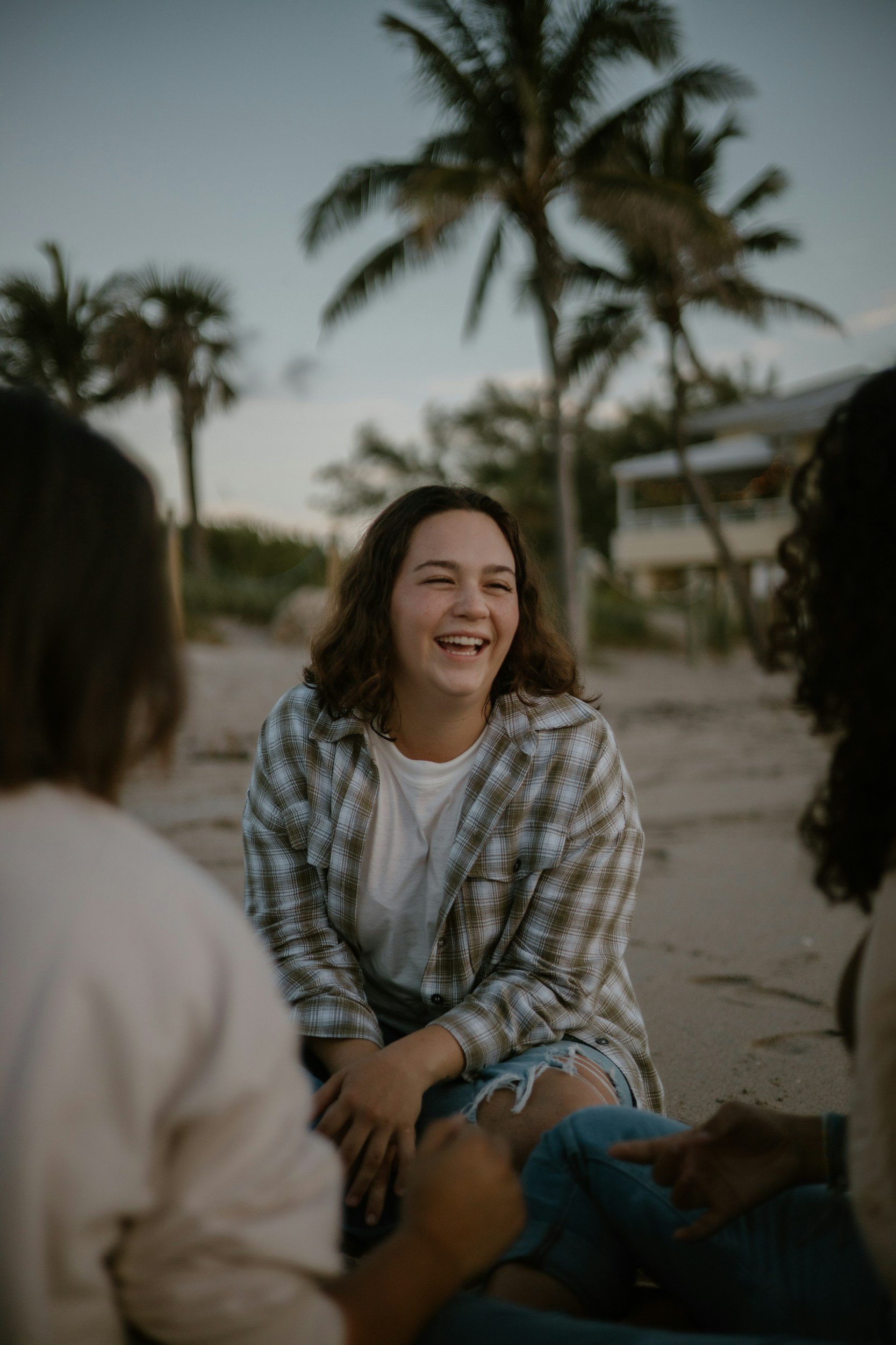 Teen girl laughing with friends outdoors beneath palm trees in Los Angeles