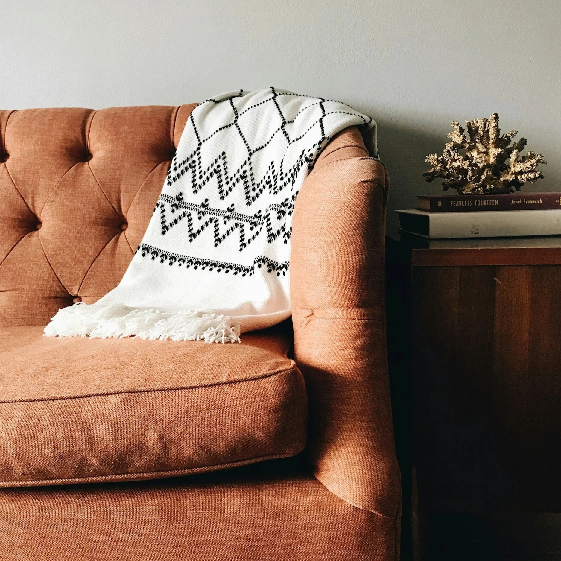“Cozy pink therapy couch with a soft white blanket.