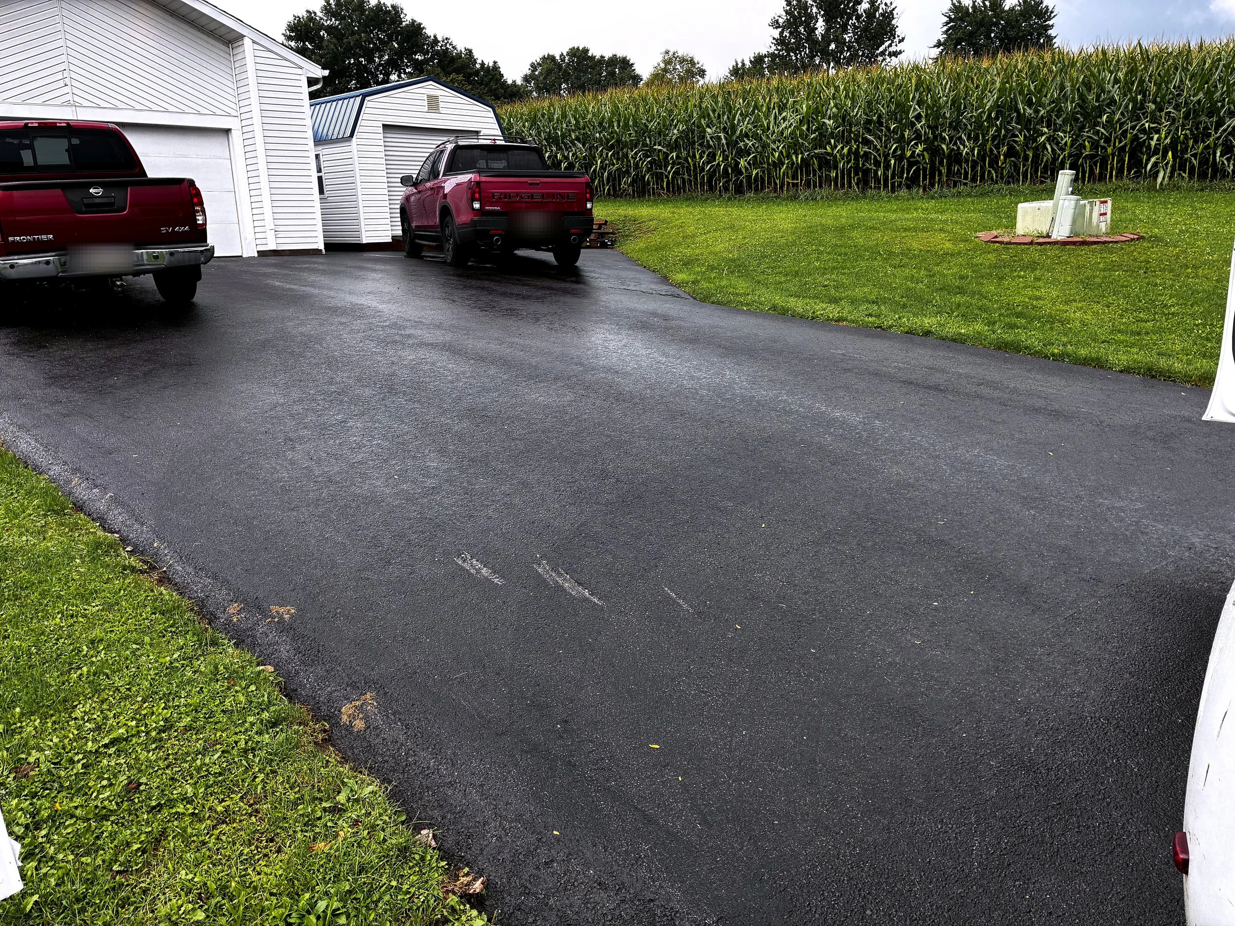 Sealed asphalt driveway and parked trucks in Butler, PA