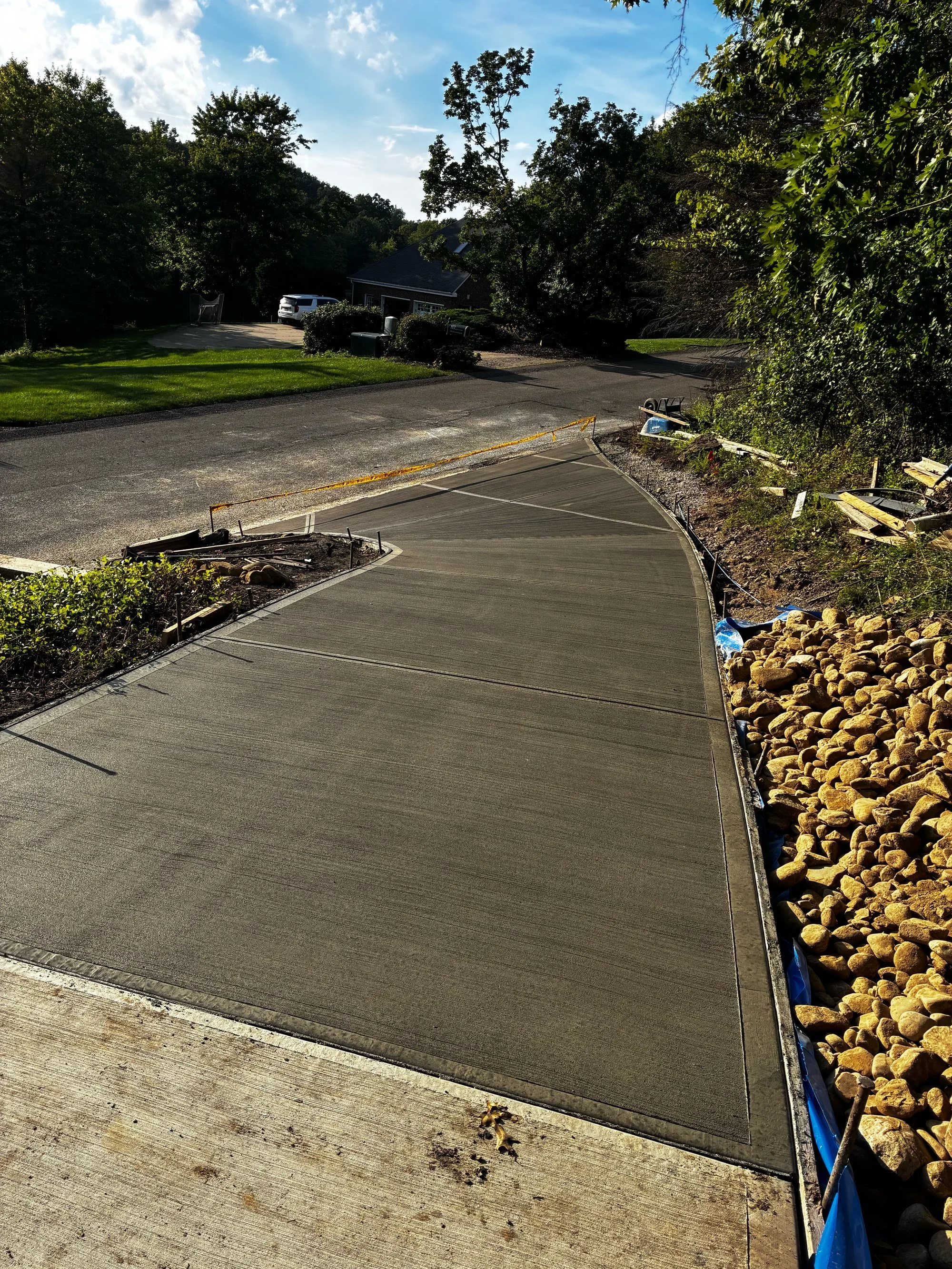 Broom-finished concrete driveway with stone edging in Butler, PA
