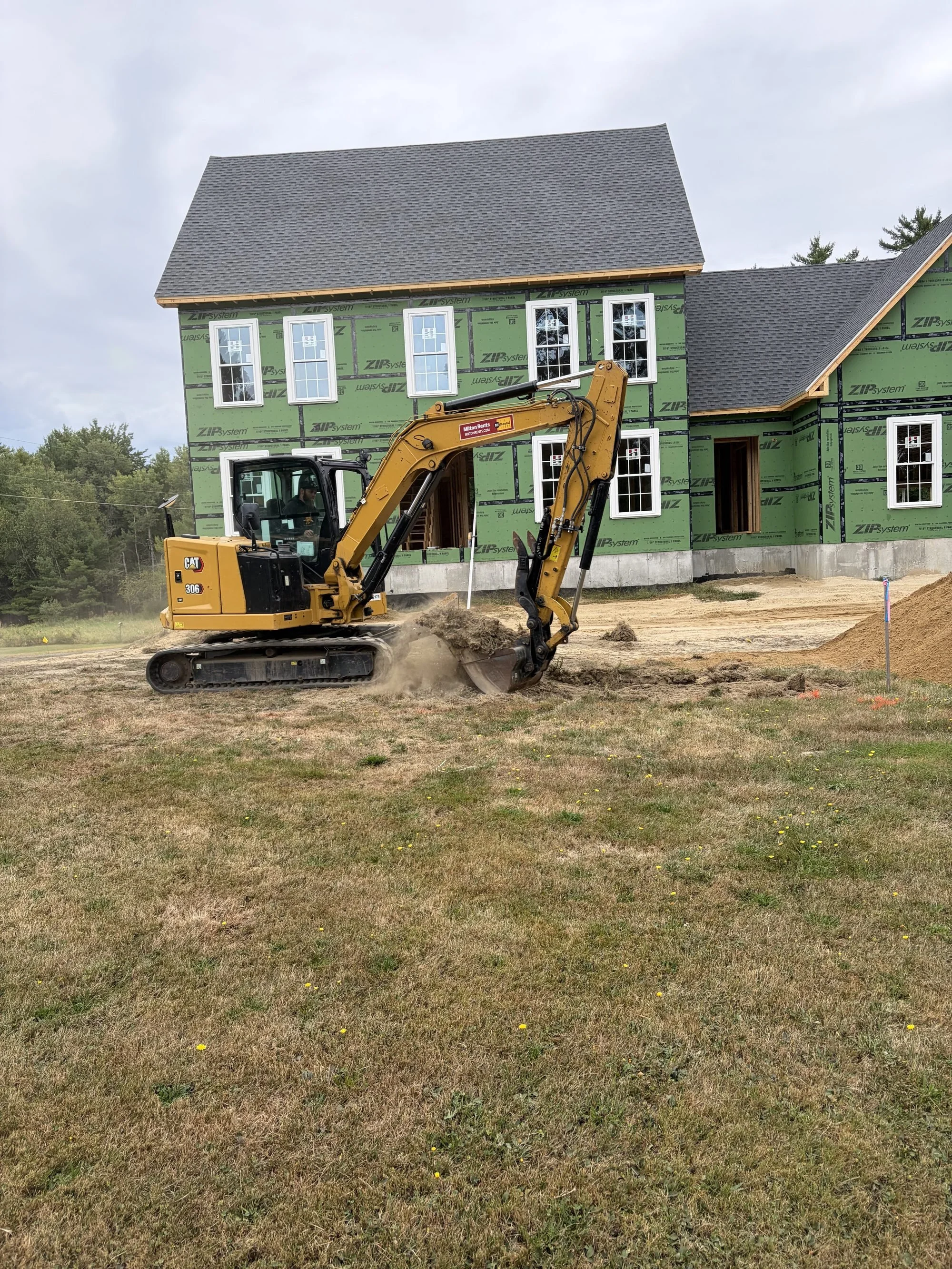 Excavator performing septic system excavation for a Maine homeowner