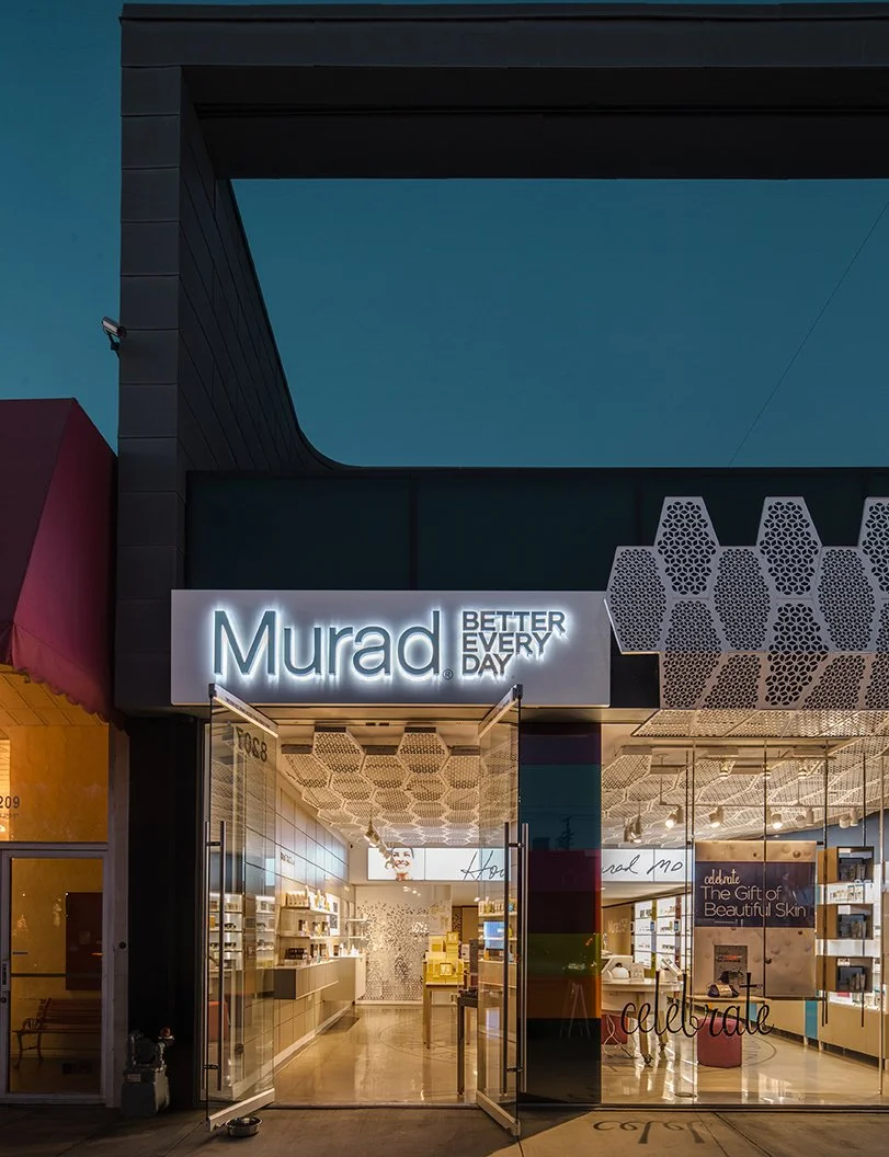 The storefront of Murad, a skincare brand, with illuminated signage and visible interior displaying shelves of products and promotional displays.