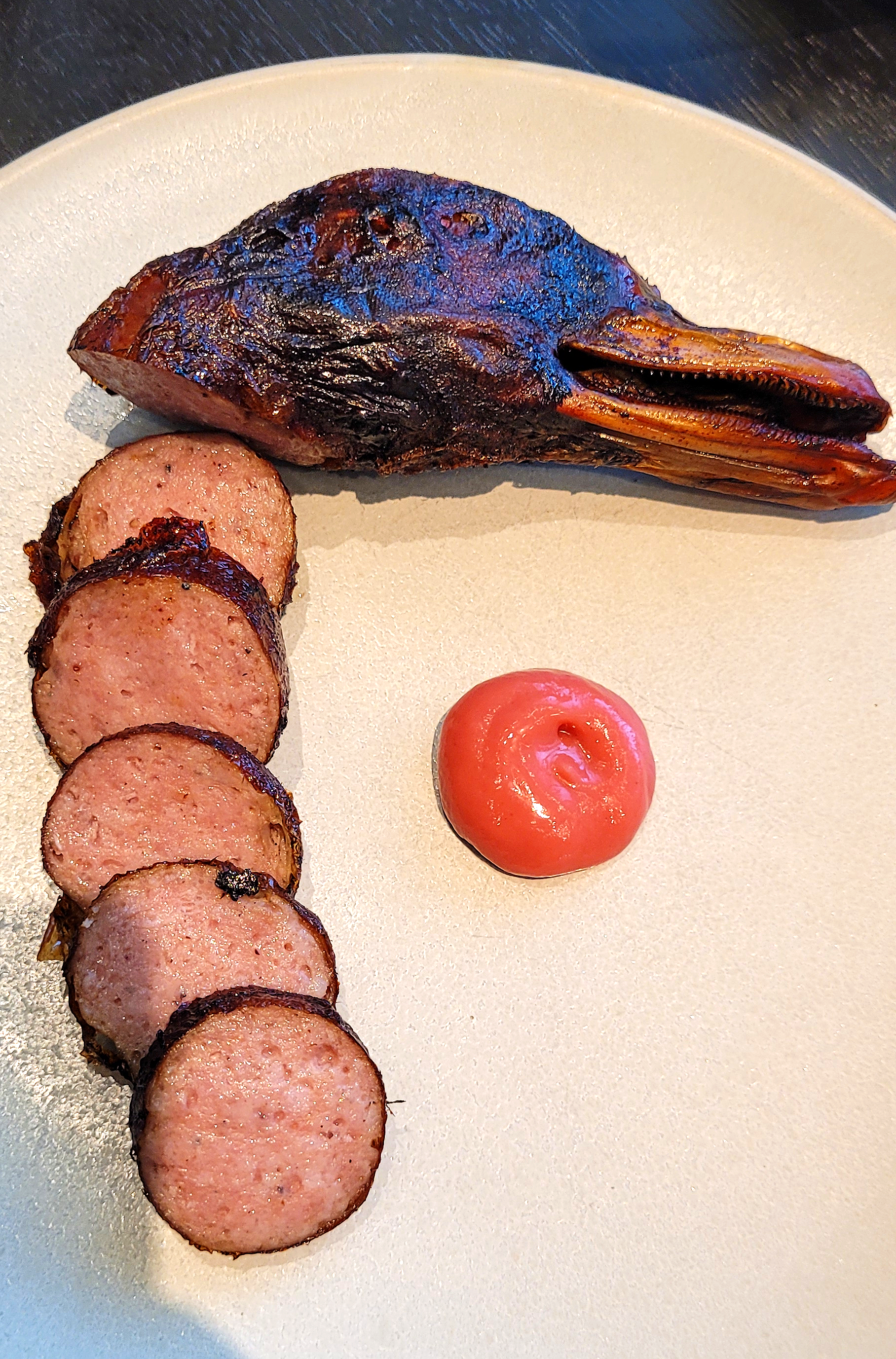 Duck sausage slices plated with head.