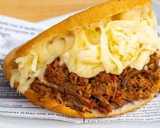 Pulled pork taco with shredded cheese in a corn tortilla