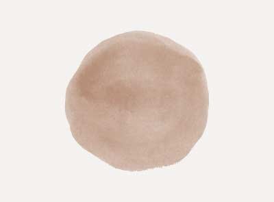 A close-up of a round, beige-colored object on a plain background.