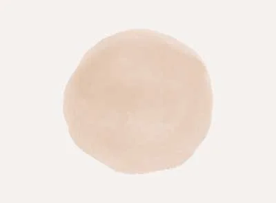 A close-up of a plain, round, beige-colored object with a slightly textured surface.