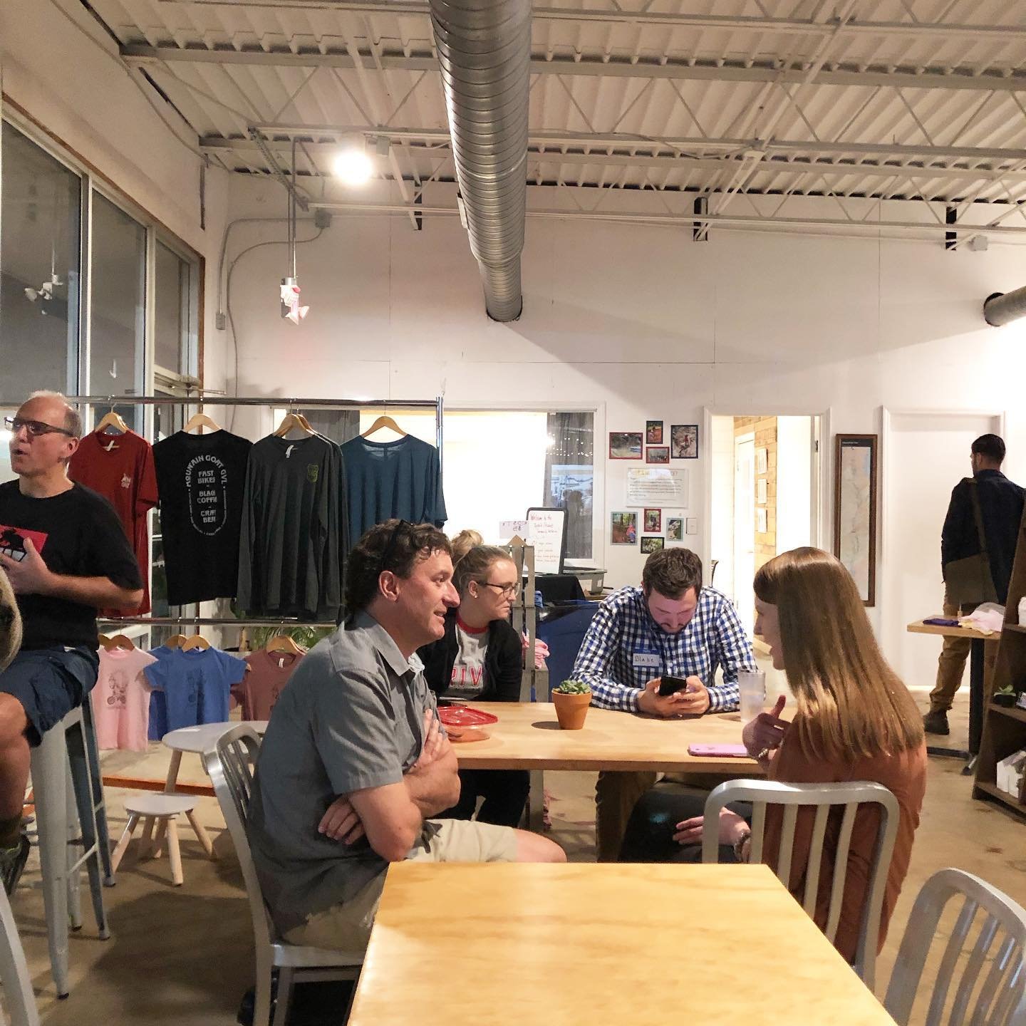 People sitting and chatting at a table inside Mountain Goat coffee shop during a monthly Upstate Stewards meeting.