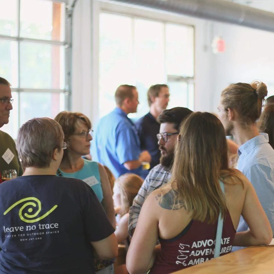 Group of people engaging in conversation at an Upstate Stewards gathering at Mountain Goat coffee shop.