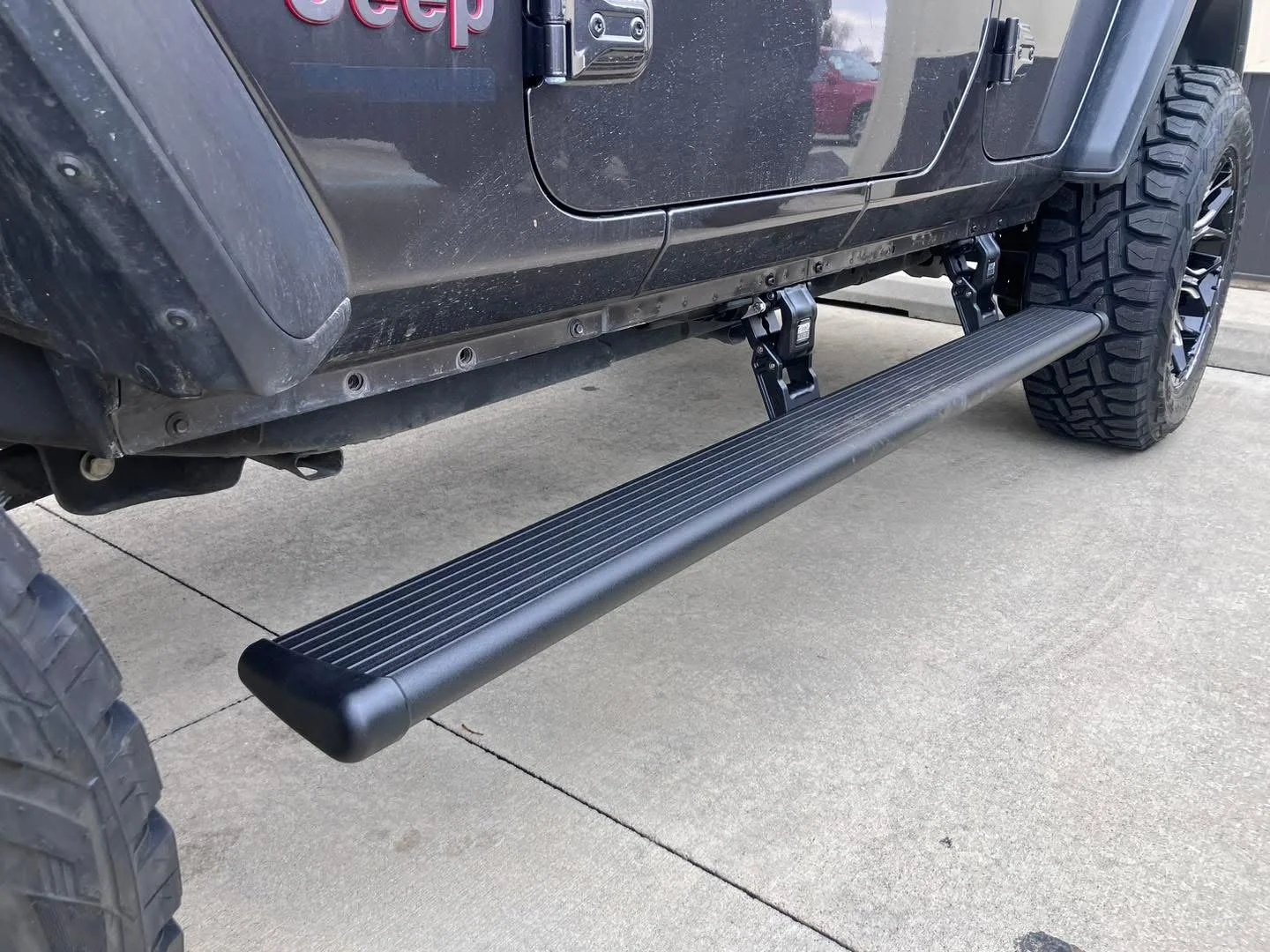 Close-up of installed running boards on a lifted truck