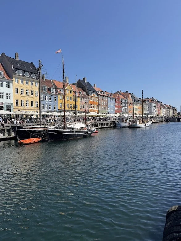 Colorful buildings and boats along a waterfront on a sunny day.