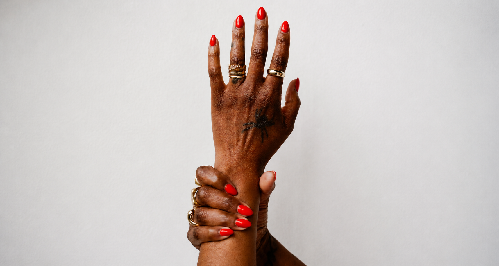 Glossy red luxury manicure with gold jewelry by Salon 2 You nail salon in Lakewood Ohio specializing in structured manicures and modern nail design.
