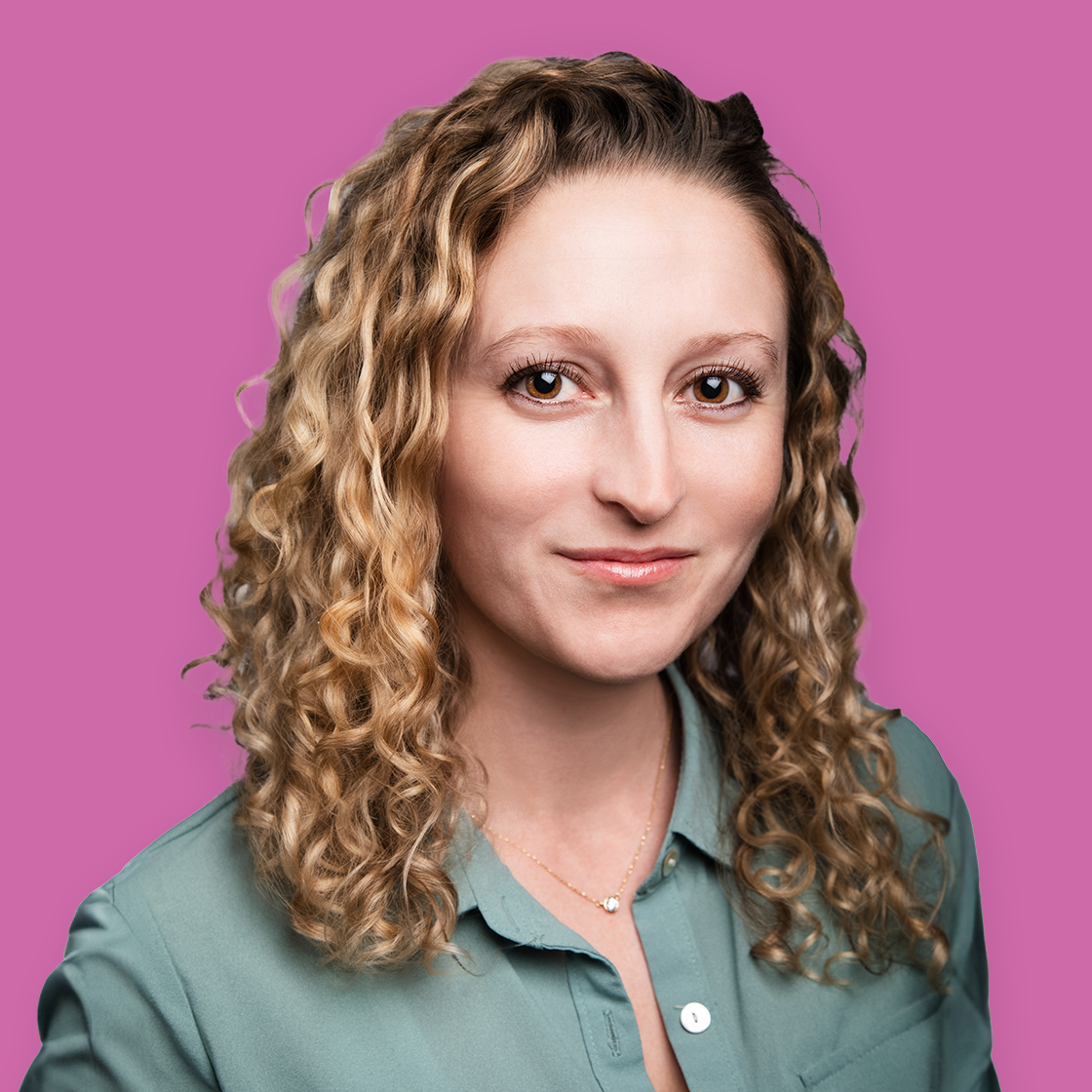 Portrait of a woman with curly blonde hair, wearing a green shirt, against a pink background.