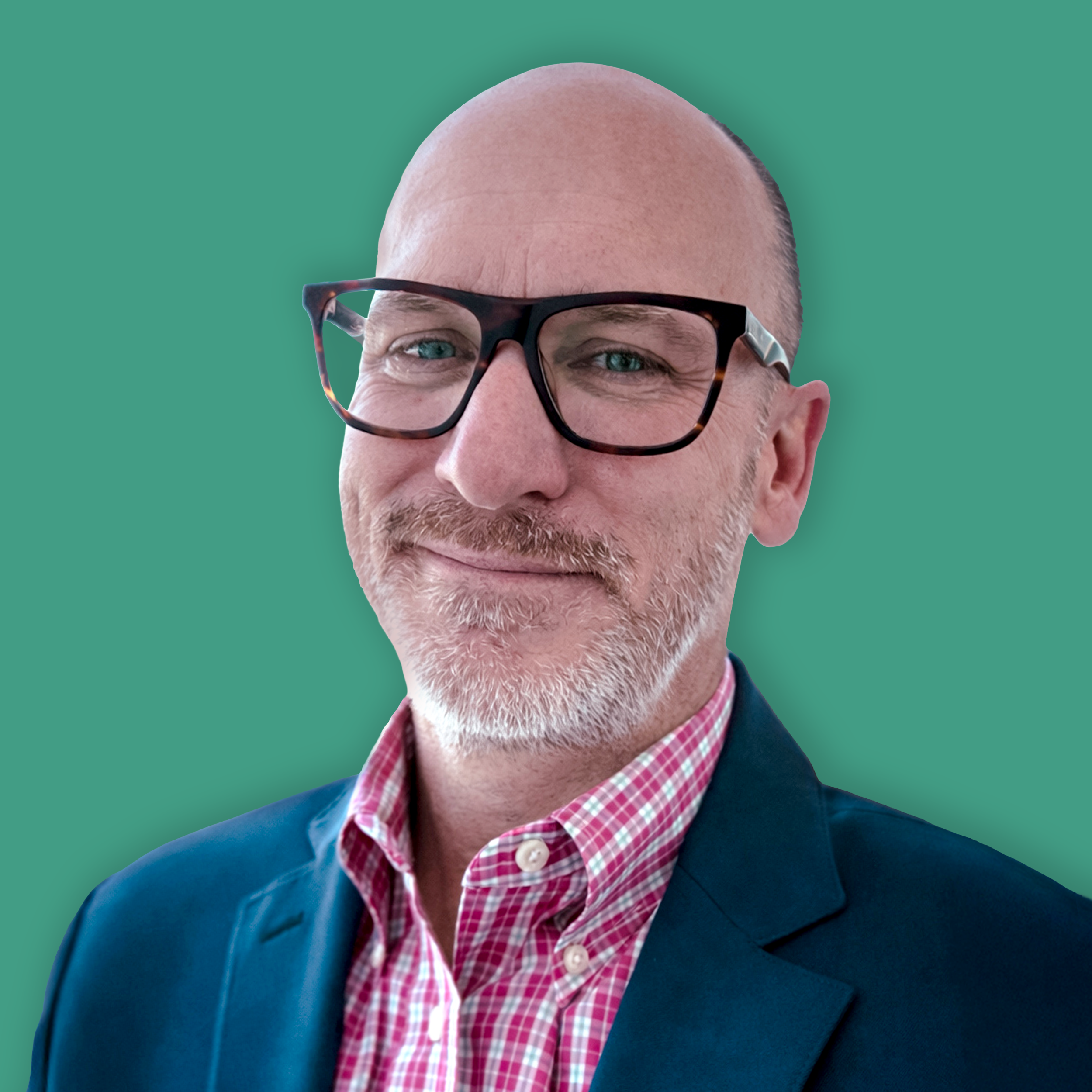 Close-up of a smiling middle-aged man with blue eyes, bald head, wearing black-rimmed glasses, a red and white checked shirt, and a navy blazer, with a solid teal background.