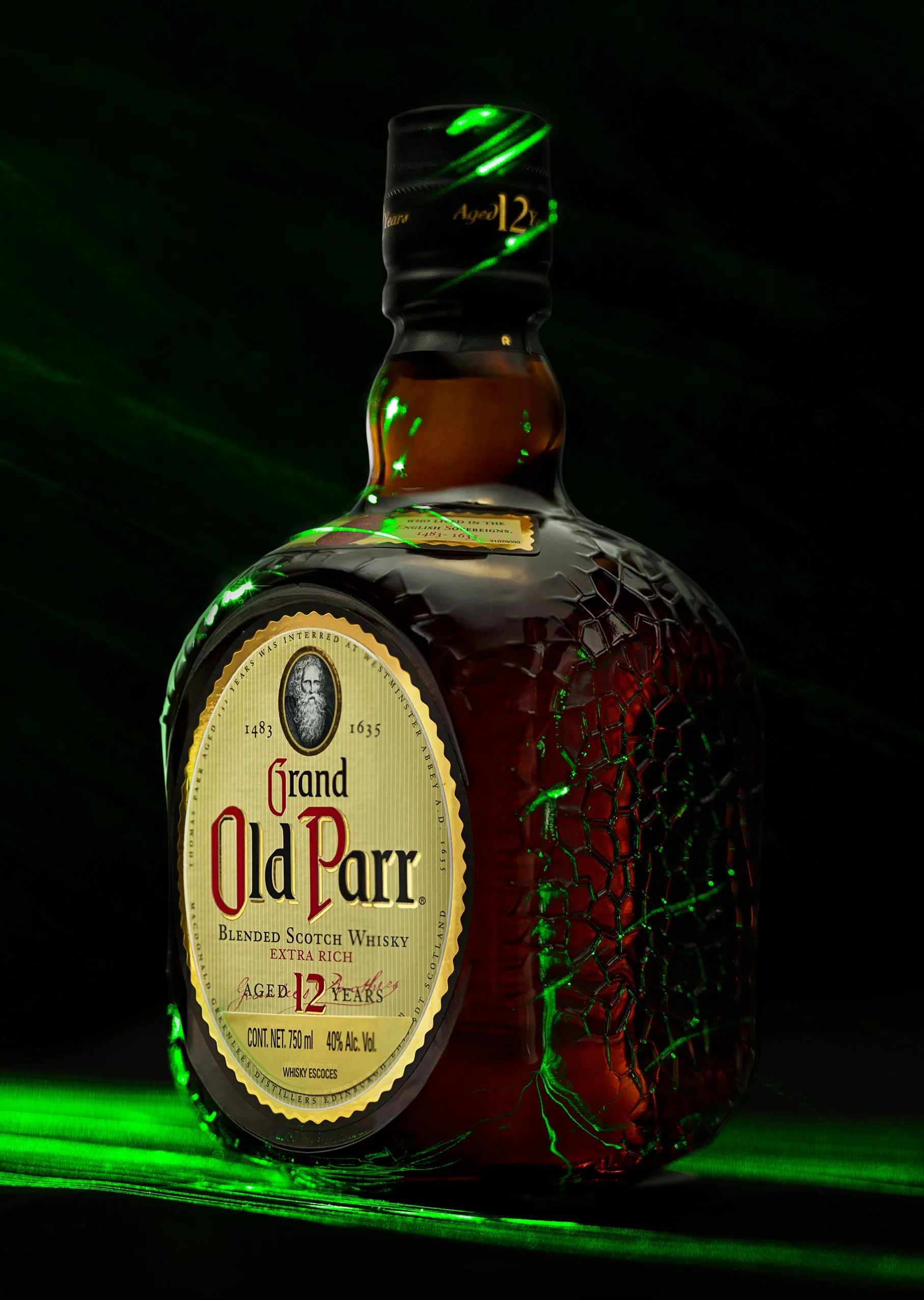 A bottle of Grand Old Parr blended Scotch whisky with a cracked glass appearance and green laser light reflections.