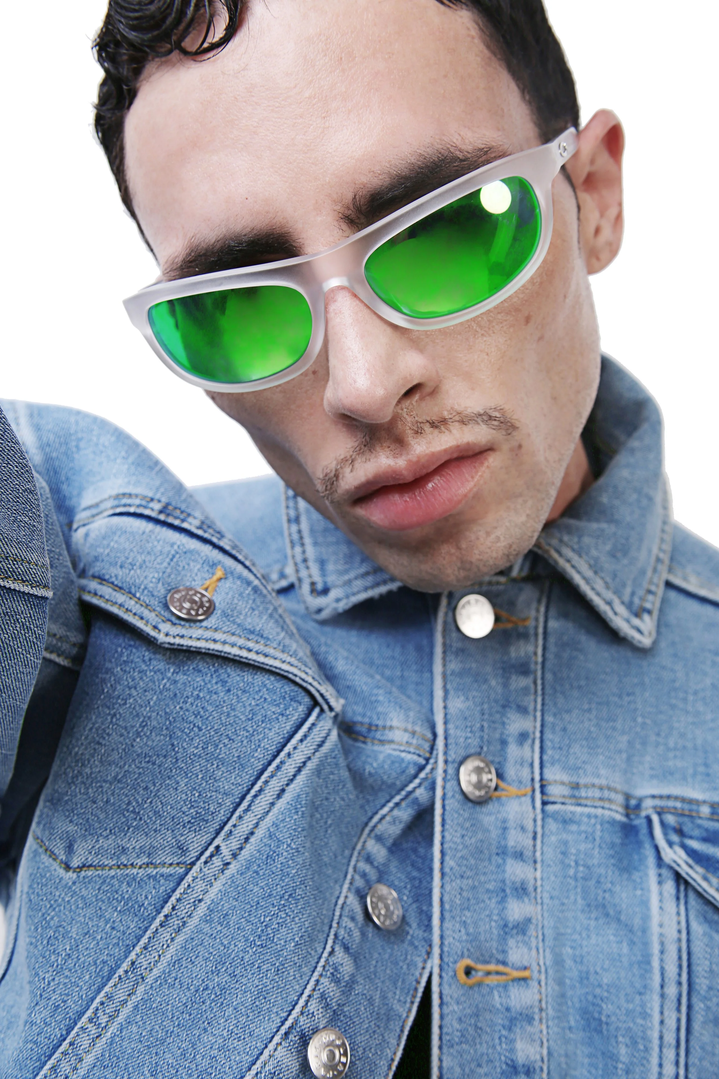 Close-up of a man wearing white-framed sunglasses with green lenses, a denim jacket, and a black shirt, with a serious expression.