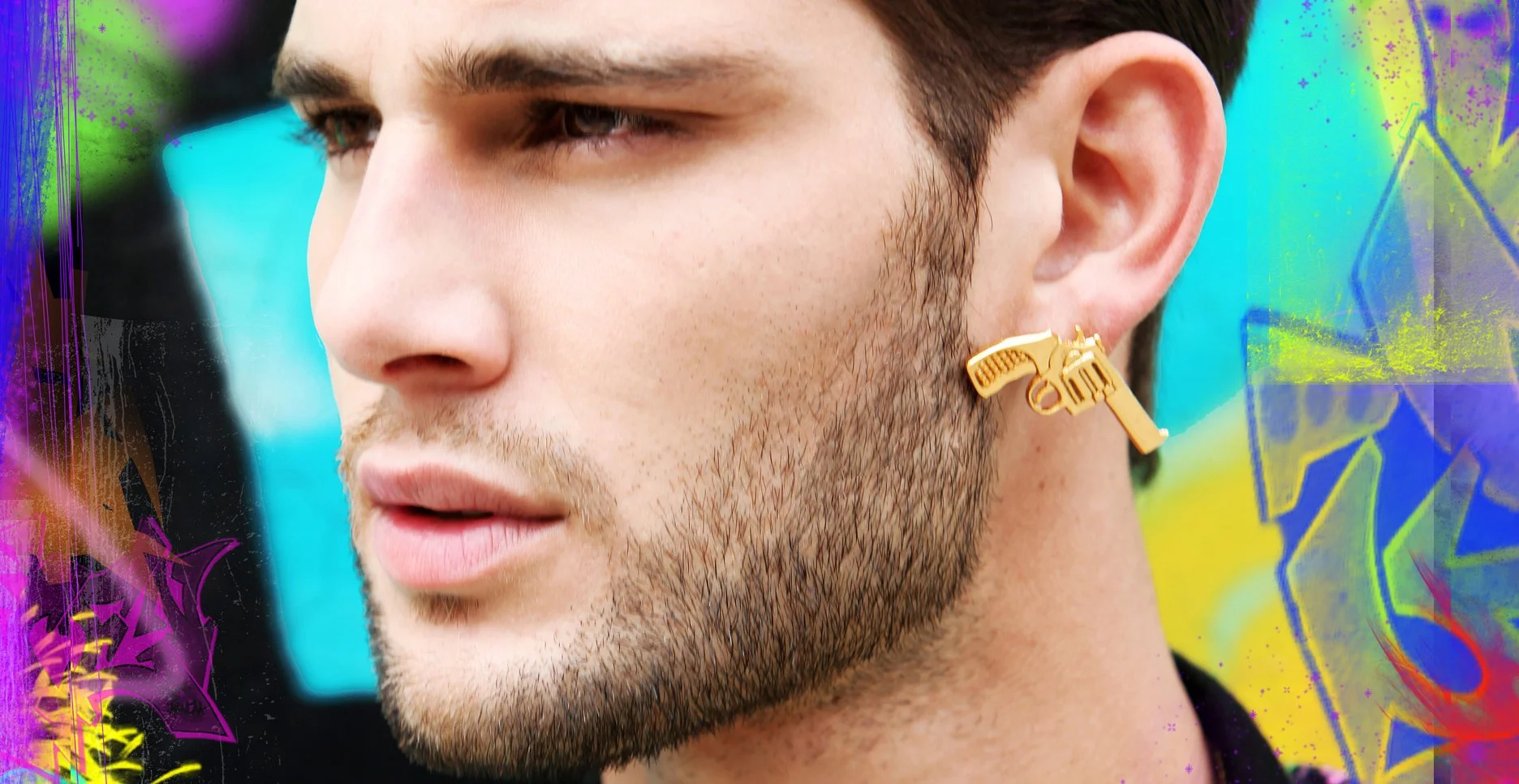 Close-up of a man with dark hair and a beard, wearing a gold earring shaped like a gun.