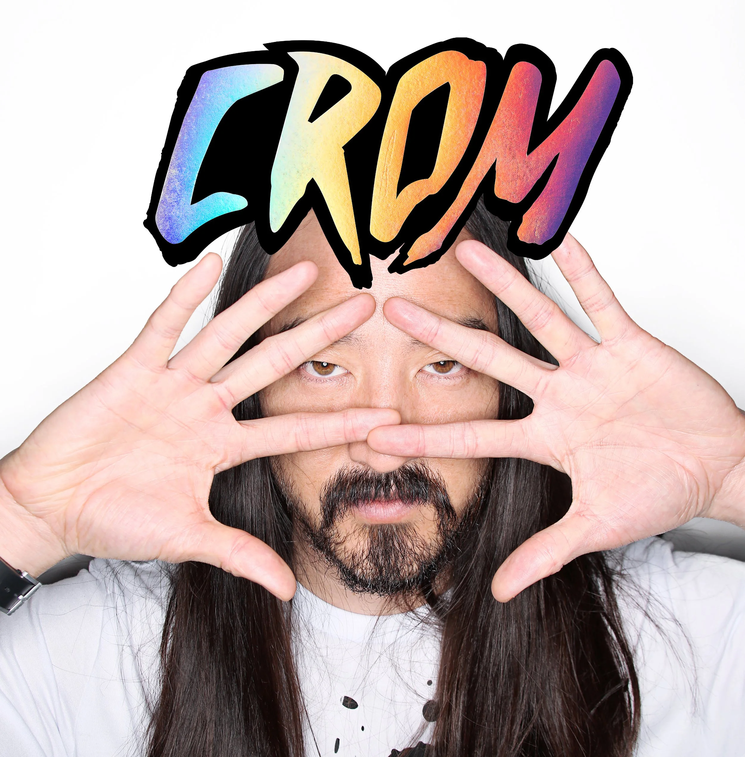Person with long dark hair making a frame with their hands around their eyes and holding a colorful sign that says 'Dream' over their forehead.
