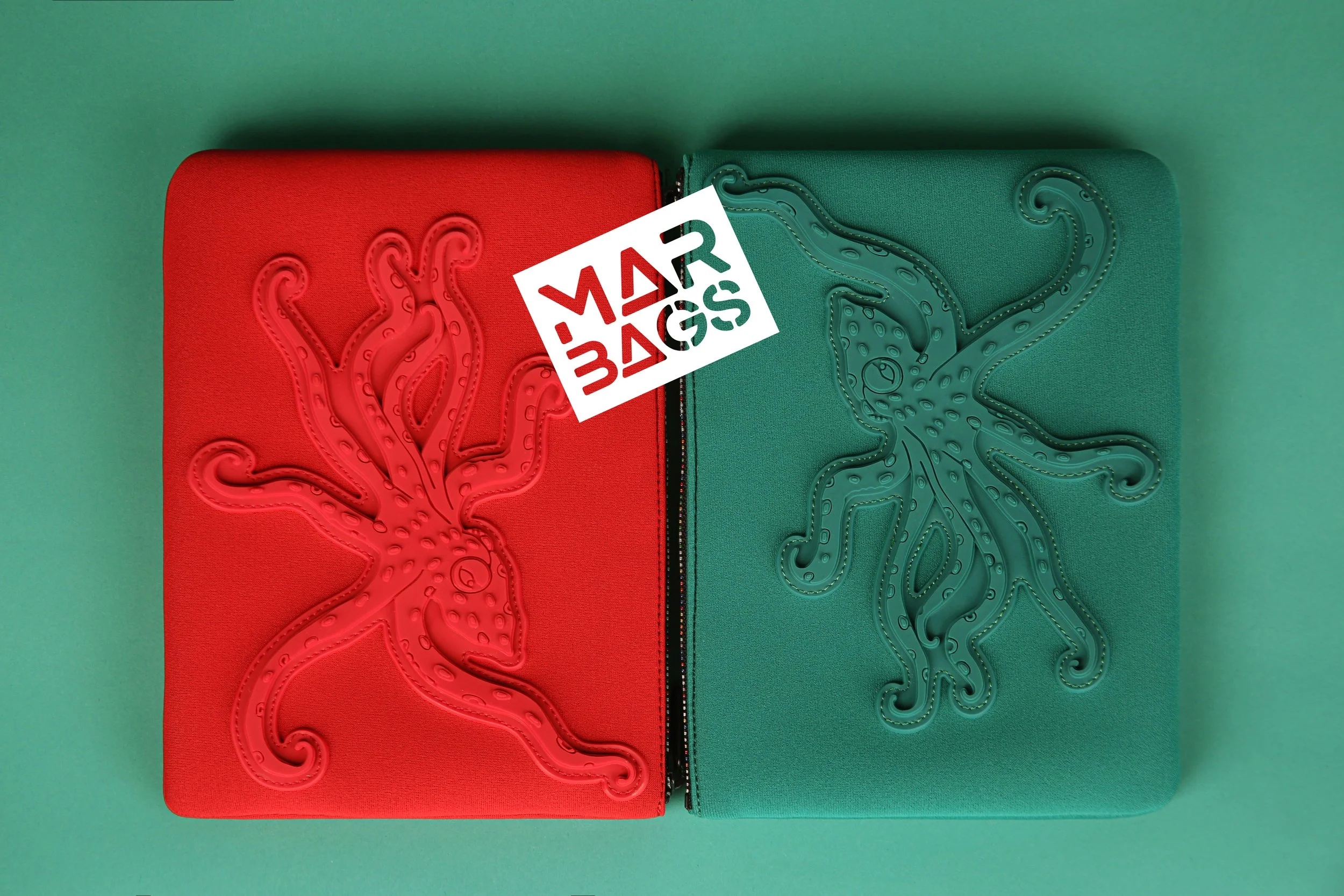 Two zippered cases, one red and one green, with embossed octopus designs, placed side by side on a green background with a "Mars Bar" sticker on the red case.