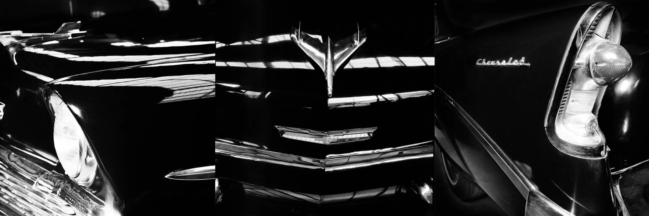 Black vintage Chevrolet car with chrome details and emblem, close-up of front and headlight.