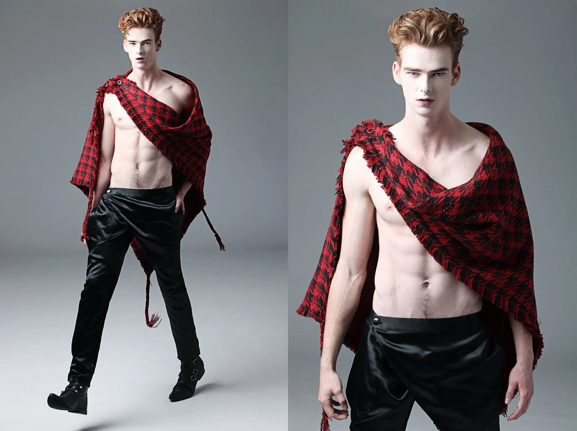 A young man with reddish curly hair wearing black pants, black boots, and a red and black patterned shawl draped over his shoulders, standing against a plain gray background.