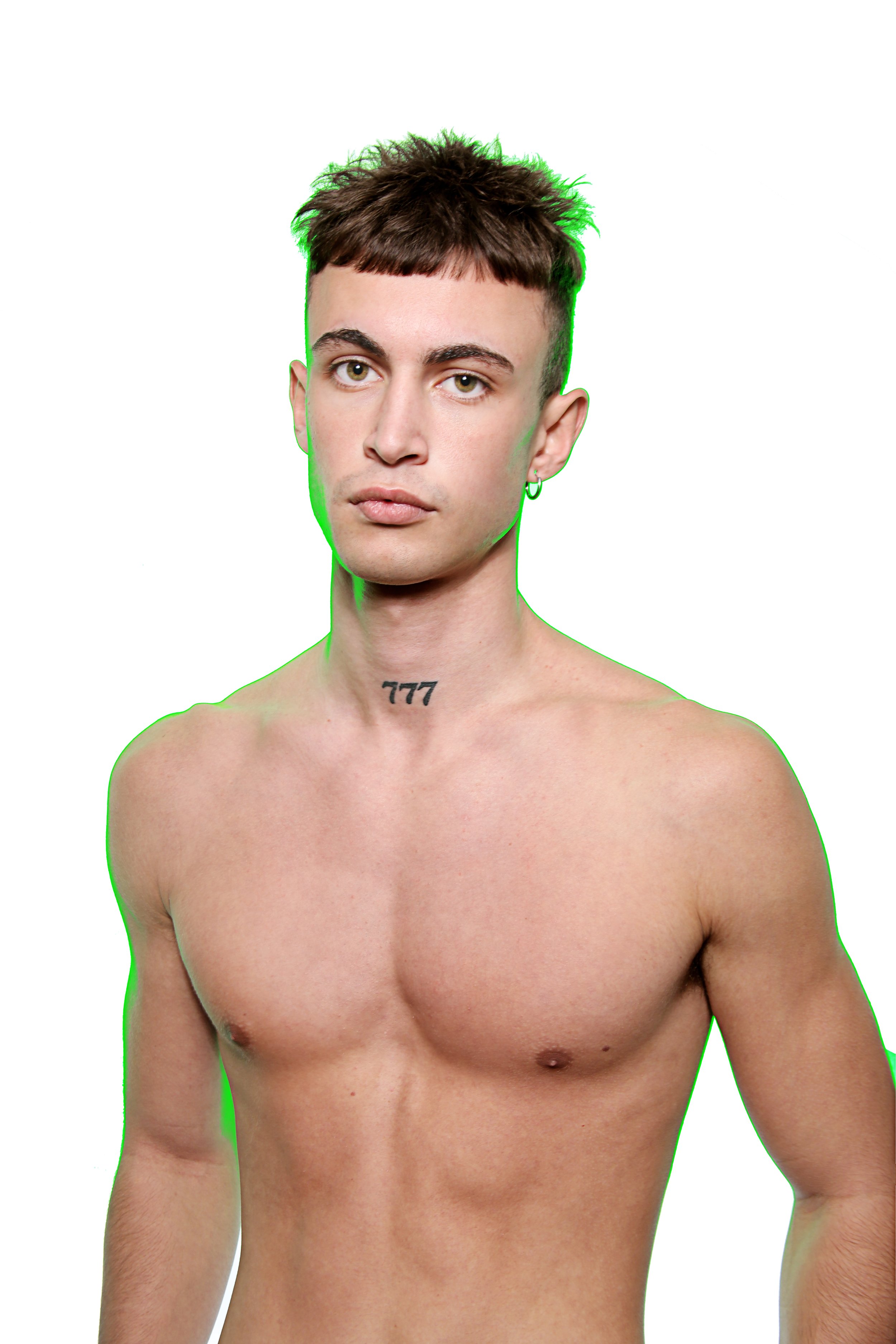 Portrait of a young man with short dark hair, green eyes, and a small hoop earring in his left ear, shirtless against a plain white background.