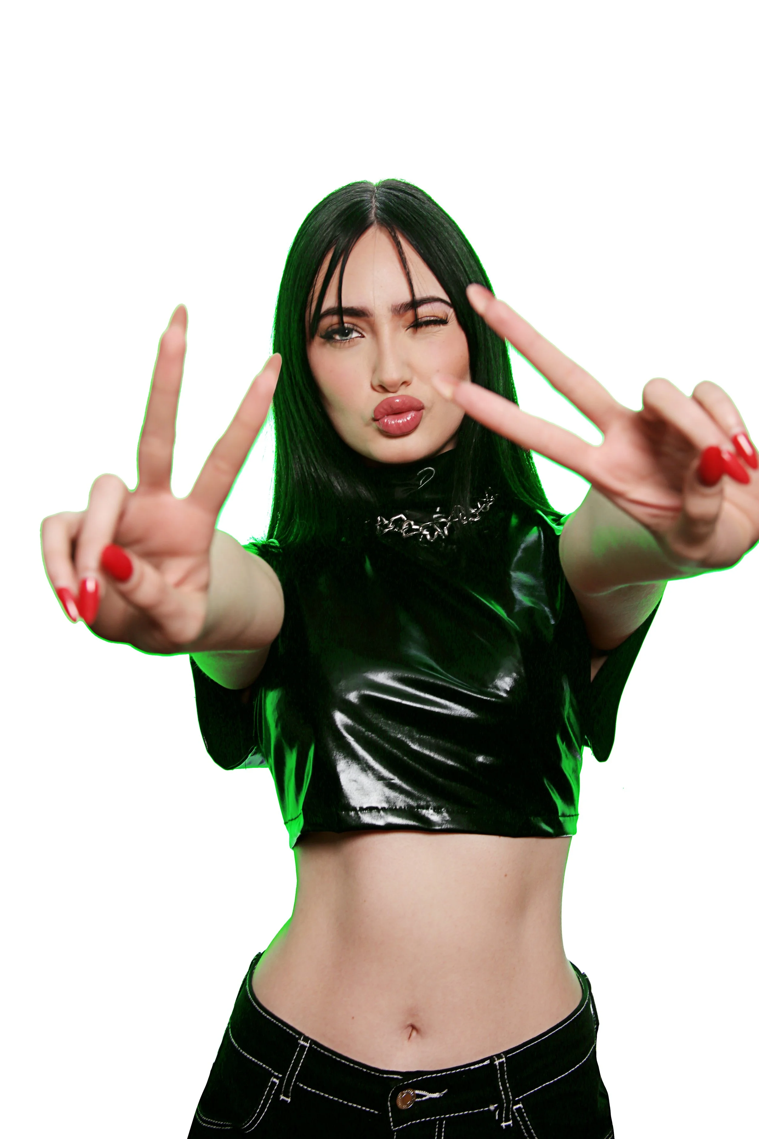 Young woman with black hair, making peace signs with both hands, wearing a shiny black top and black pants, with a white background.