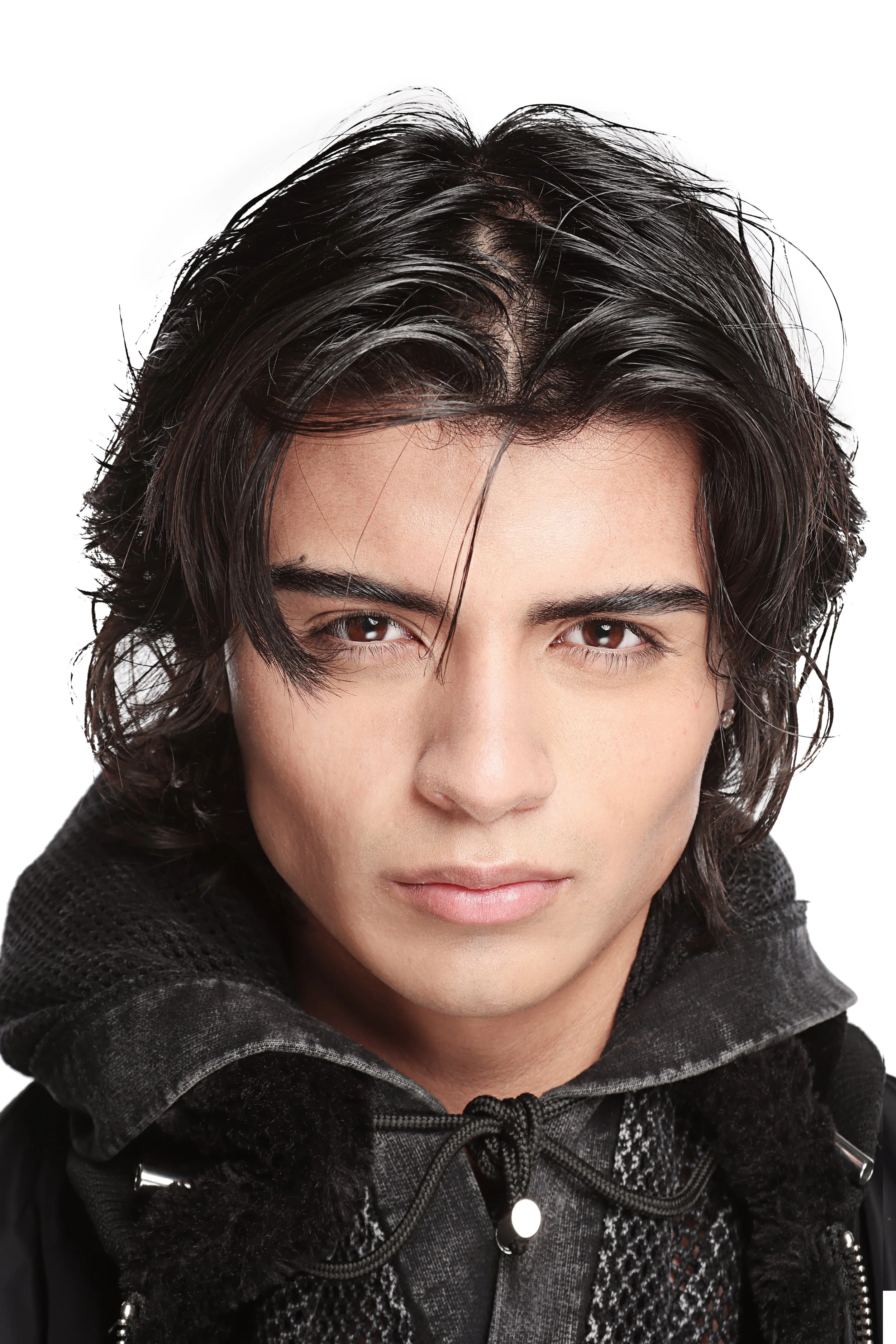 Close-up of a person's face with wet, black hair and brown eyes, wearing a black textured hoodie.