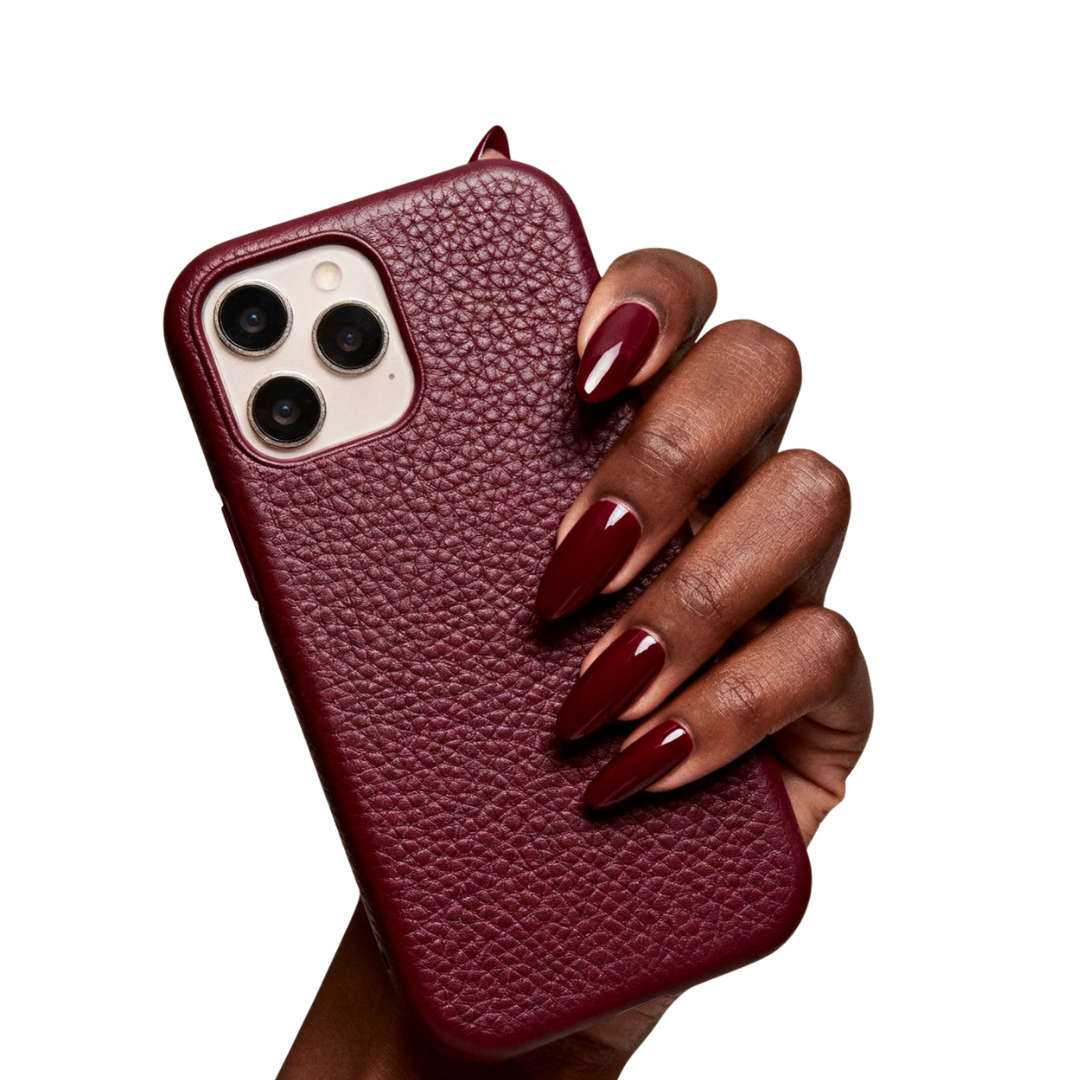 Hand holding a red leather phone case with a triple camera phone inside.
