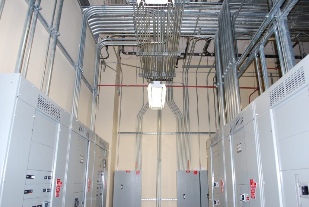 Electrical rooms with circuit breaker panels and electrical conduit wiring.