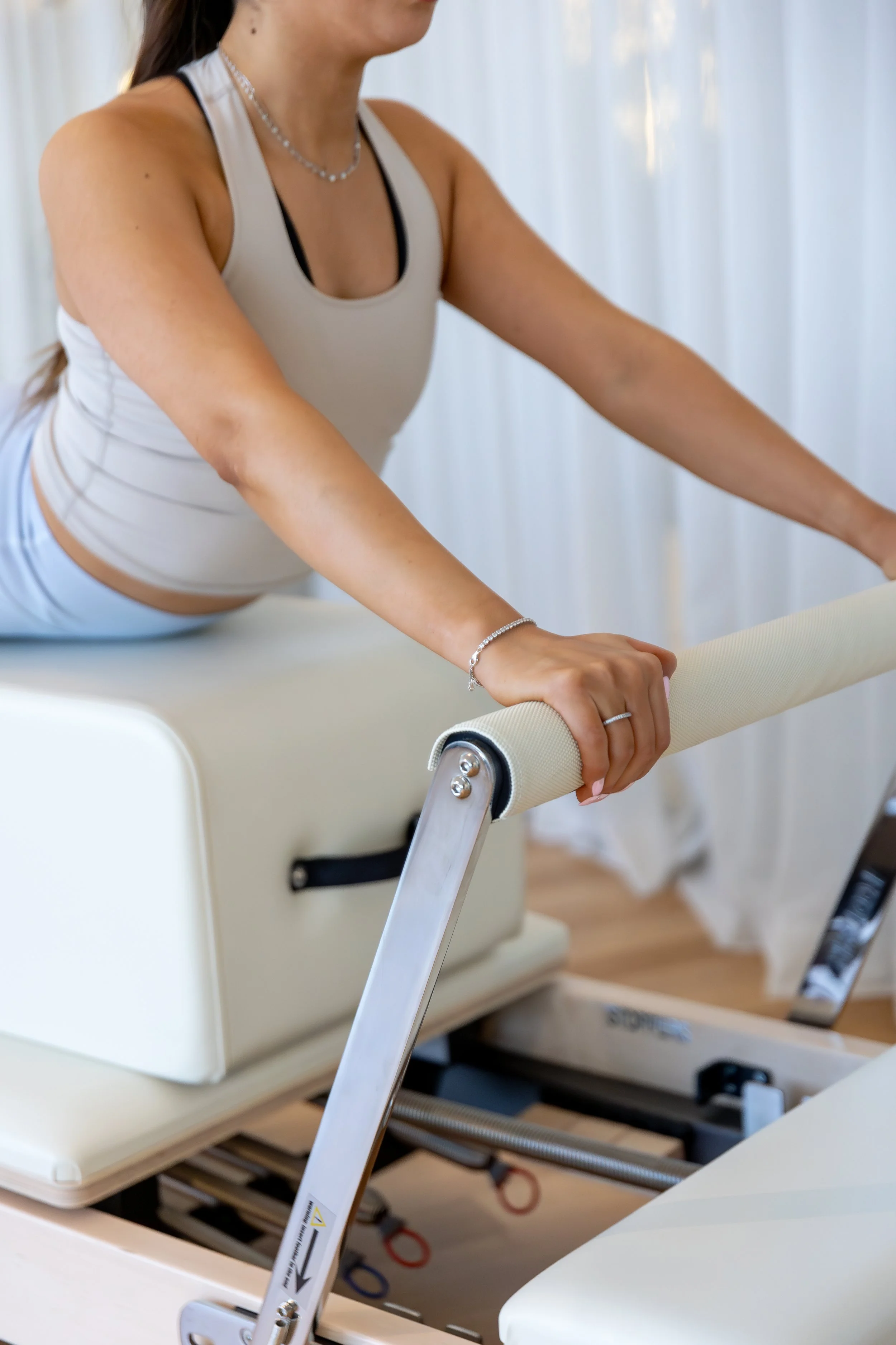 Close-up of a woman in athletic clothing doing physical therapy on a specialized medical table with a foam roller.