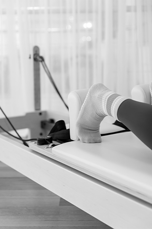 A person wearing a sock and a prosthetic leg undergoing physical therapy with an exercise machine.