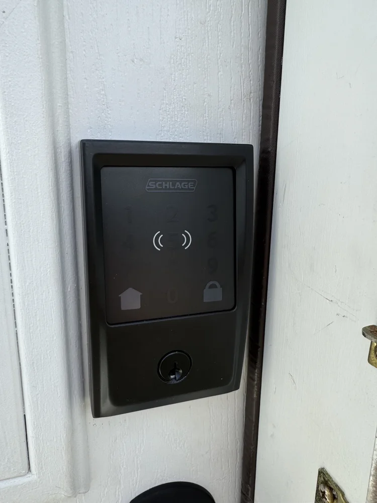 Smart lock with keypad installed on a white entry door
