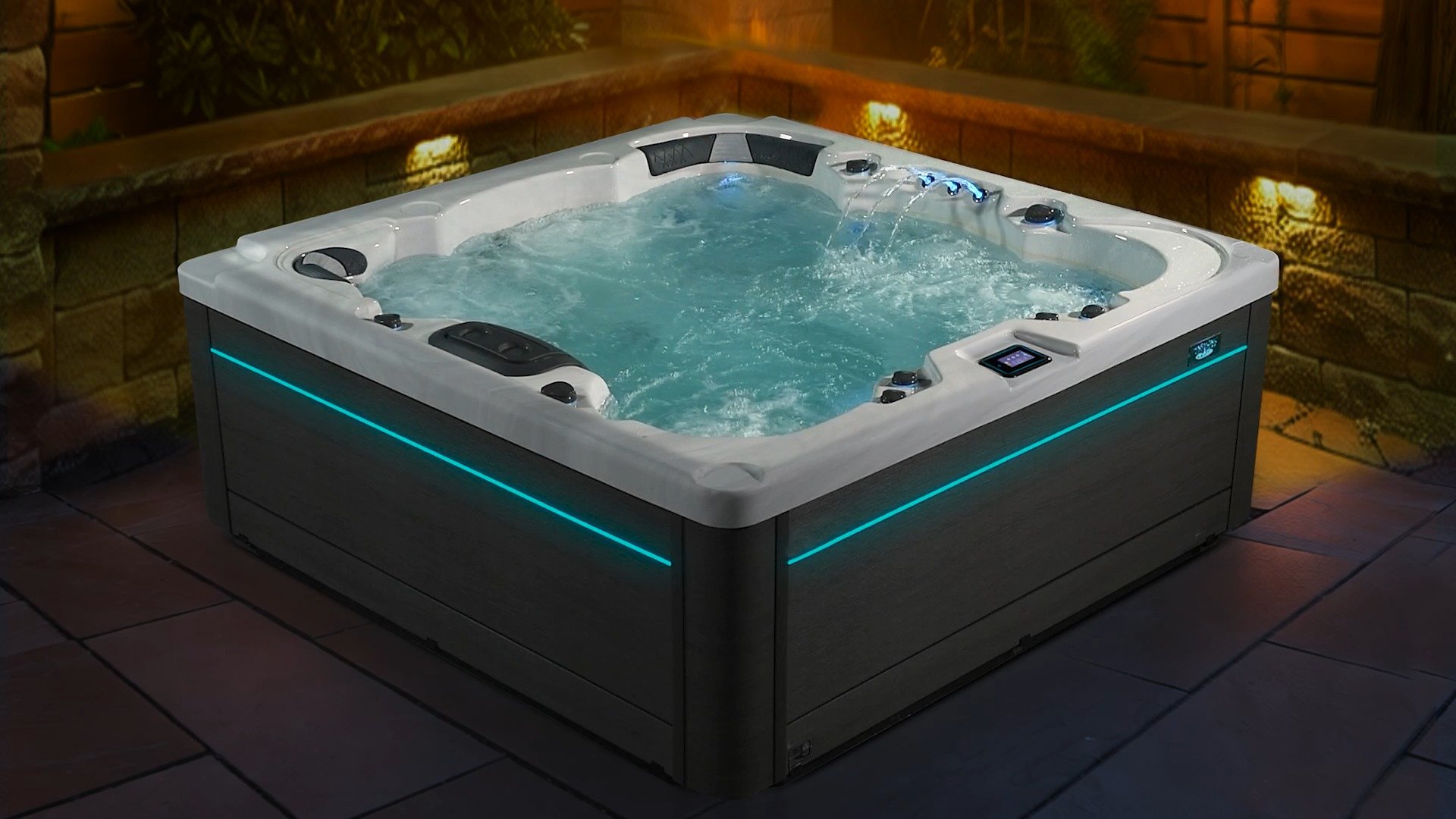 Modern hot tub with bubbling water, illuminated by blue LED lighting, situated outdoors with brick and stone walls at night.