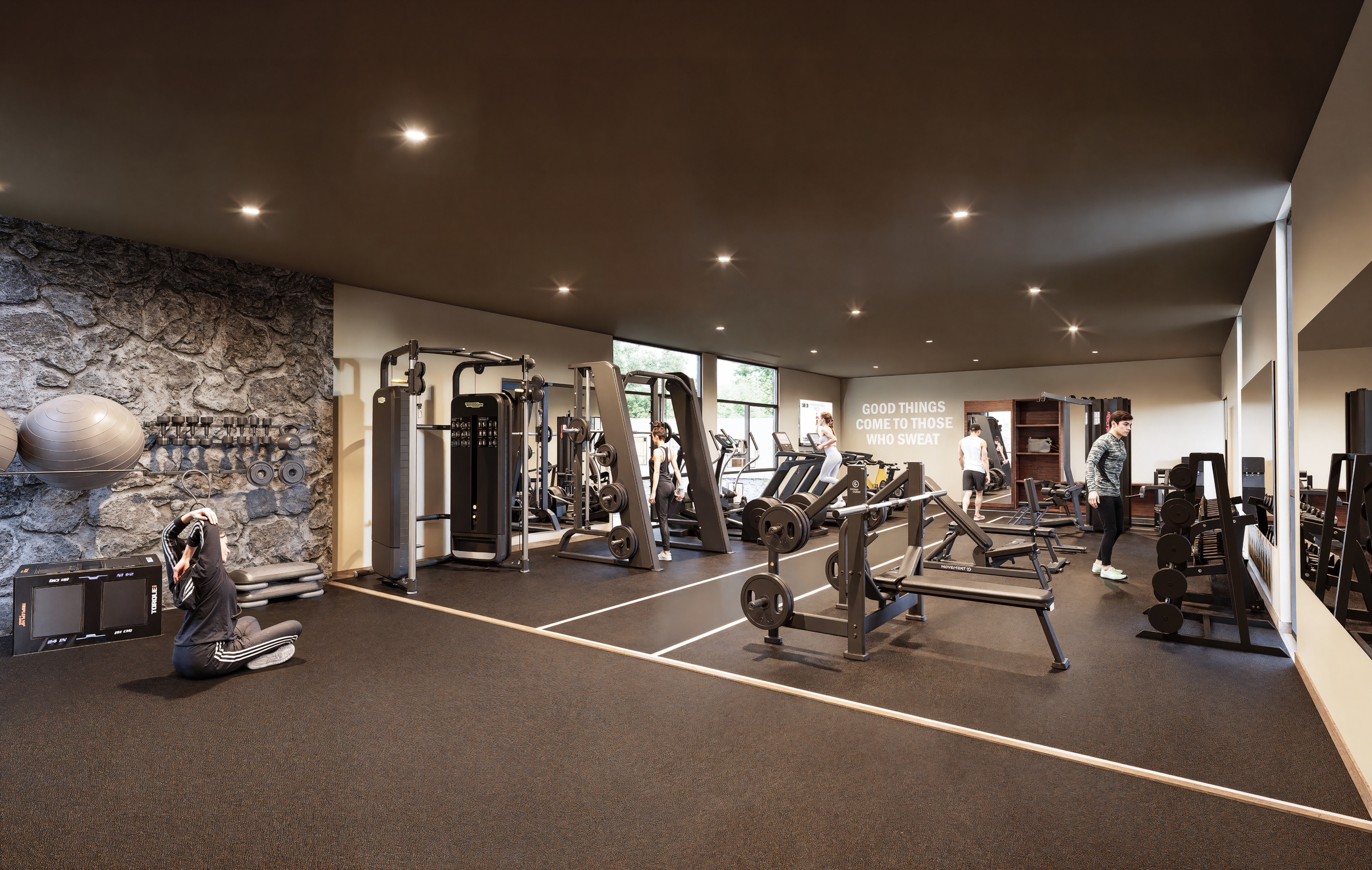 El gimnasio de Eliá rompe con la estética tradicional de los gimnasios residenciales al incorporar un interiorismo de alto nivel. La continuación de los muros de acento en piedra natural, plafones oscuros y equipamiento de vanguardia, crea un ambient