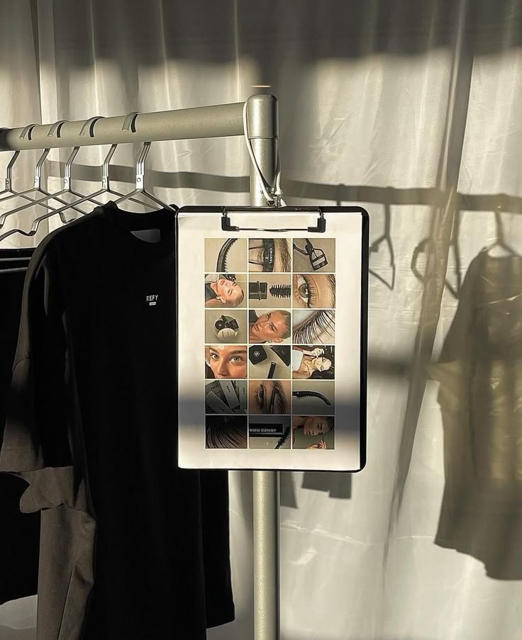 Painel com várias fotos de close-up de olhos, maquiagem e produtos de beleza, suspenso em um cabideiro ao lado de roupas.