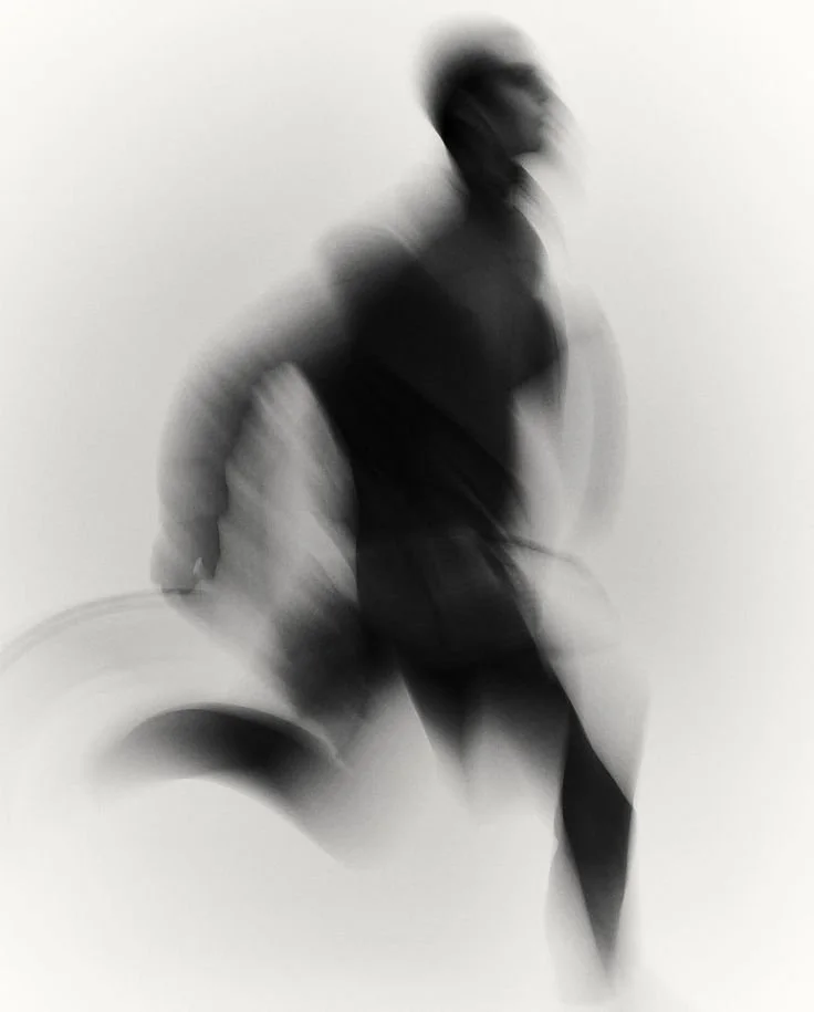 Pessoa em movimento, visão borrada, com fundo branco.