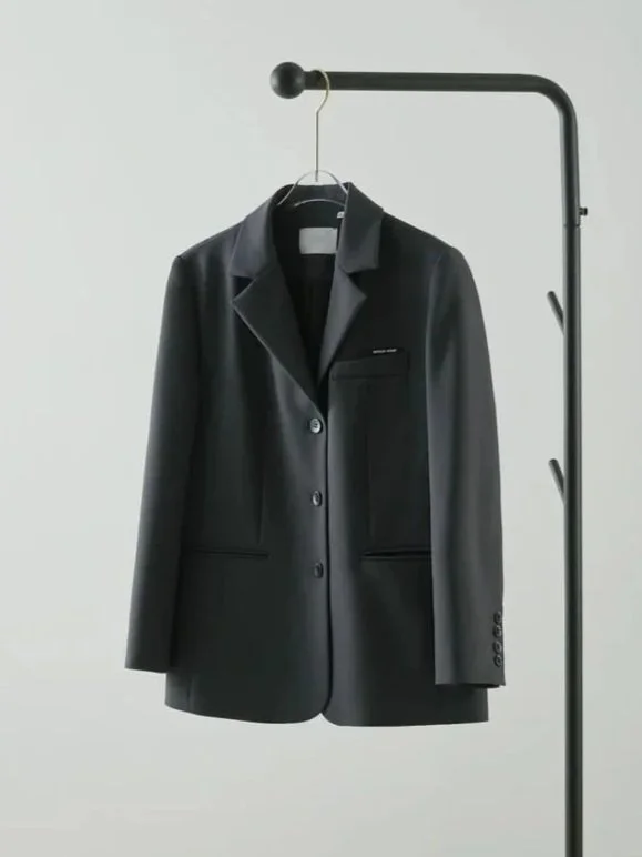Paletó preto de blazer pendurado em cabideiro preto