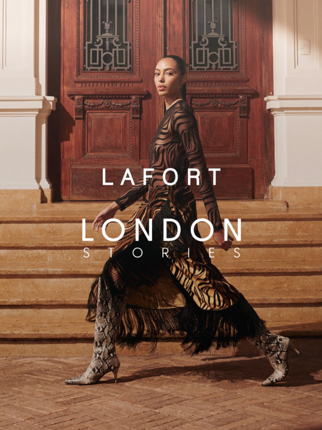 Imagem de uma mulher posando em frente a uma escadaria de madeira, vestindo roupa de estampa de zebra e botas de bico fino. Texto na imagem: "LaFort London Stories".