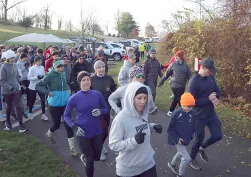People participating in a group outdoor walk or run, dressed in warm clothing.