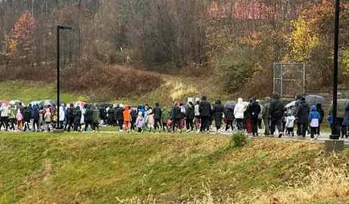 Group of people walking outdoors in a park during fall.