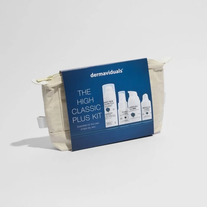 A beige toiletry bag with a blue label showing dermaviduals skincare products, titled "The High Classic Plus Kit," for dry skin.