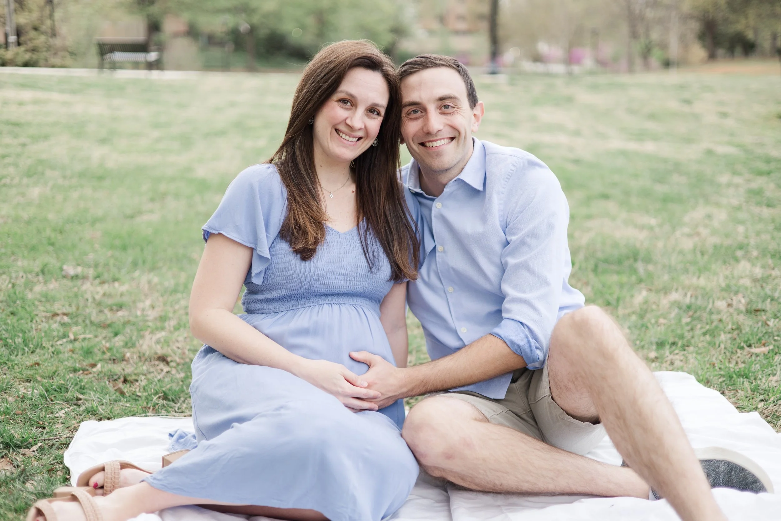 Expectant mother and father wearing a flowing blue dress during an outdoor maternity session in Charlotte, North Carolina