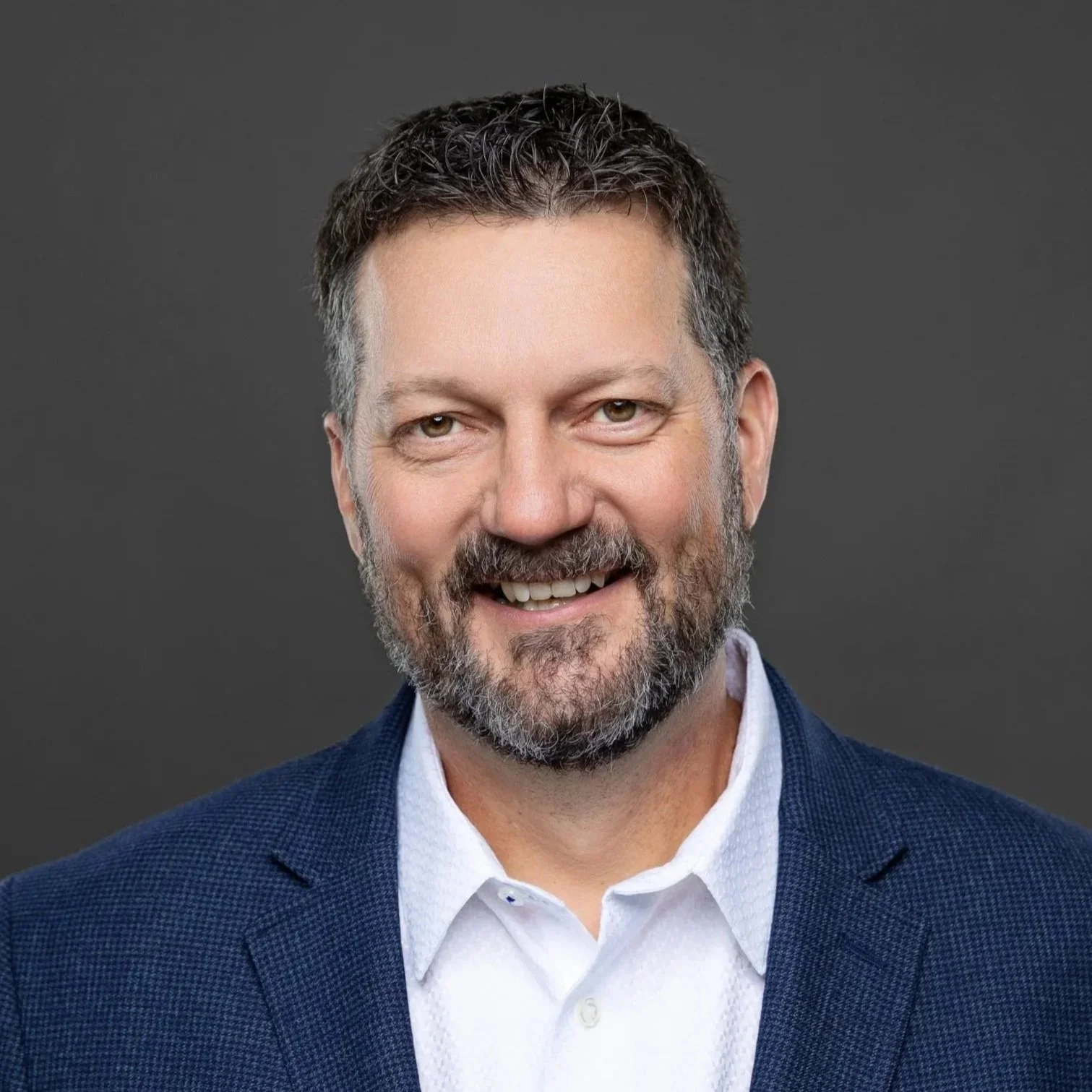 Smiling bearded man in a navy blazer, business headshot by Square Mouth Studios