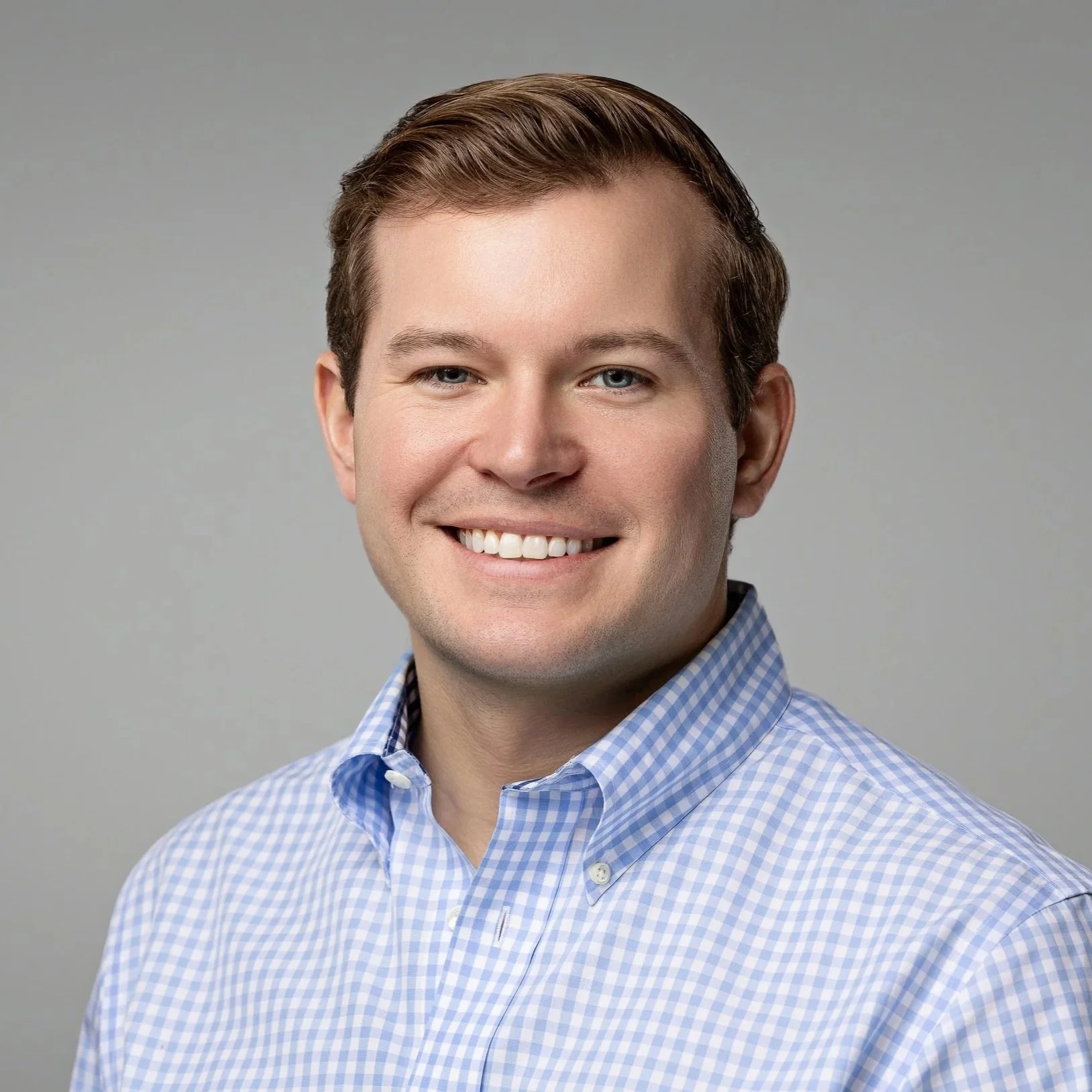 Smiling young man in a light blue button-down shirt, business headshot in Fishers, Indiana