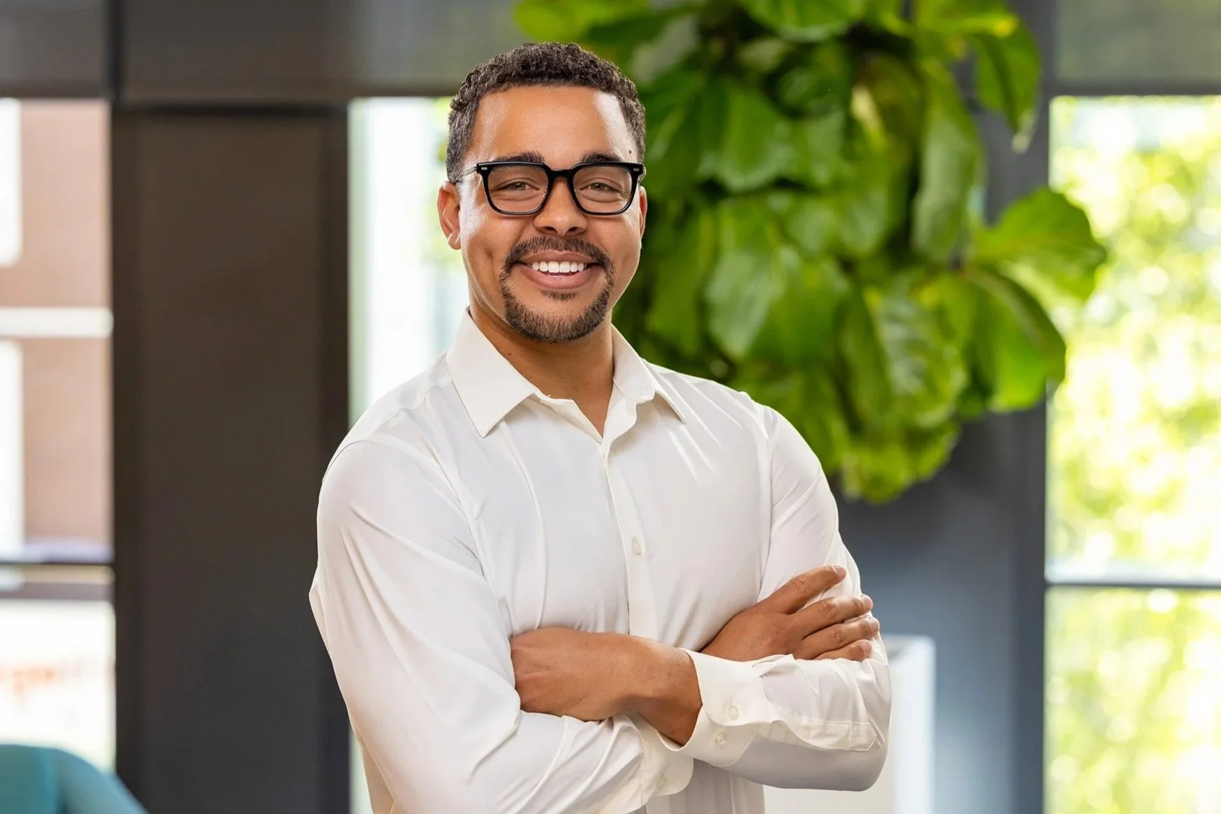 Smiling man in glasses and a white shirt with arms crossed, Cummins employee portrait in Indianapolis