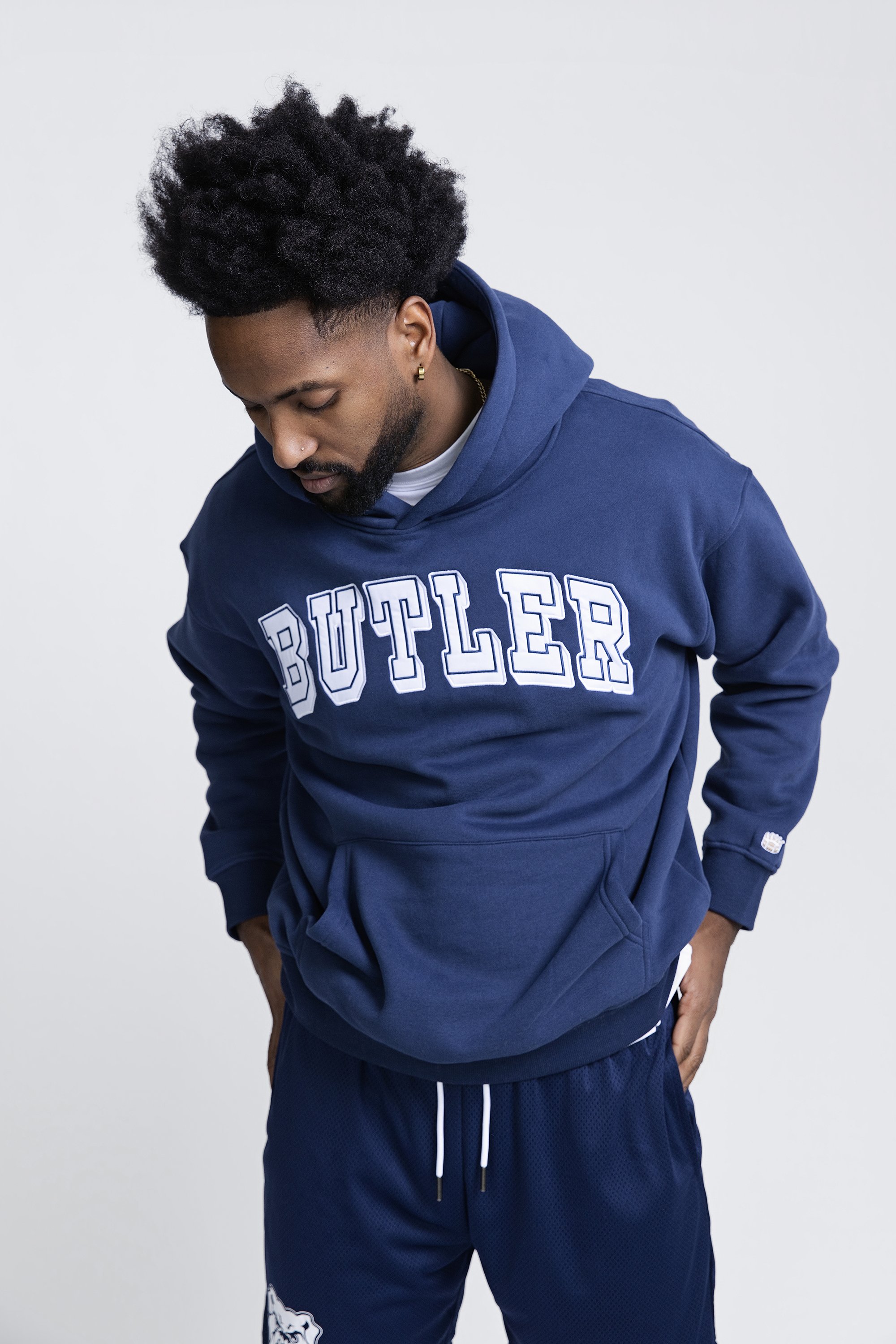 Model in a navy Butler hoodie and sweatpants, Homefield Apparel studio photography in Fishers