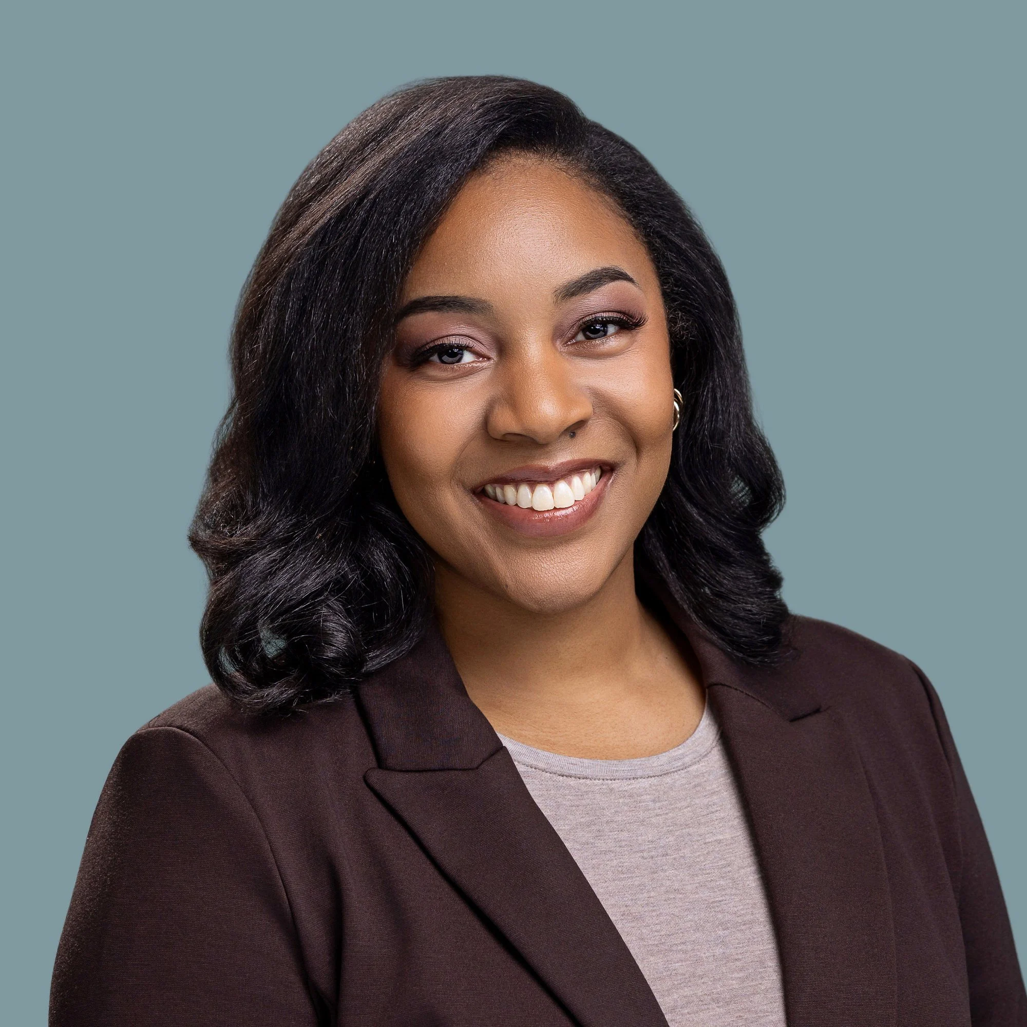 Smiling woman in a burgundy blazer, professional headshot by Square Mouth Studios