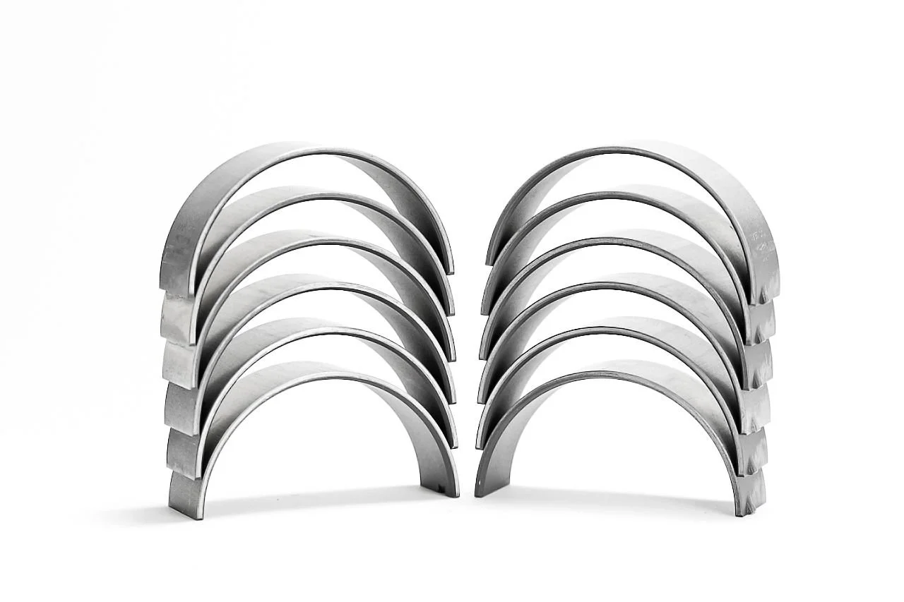 Stacked metal engine bearings on white, studio product photography in Fishers