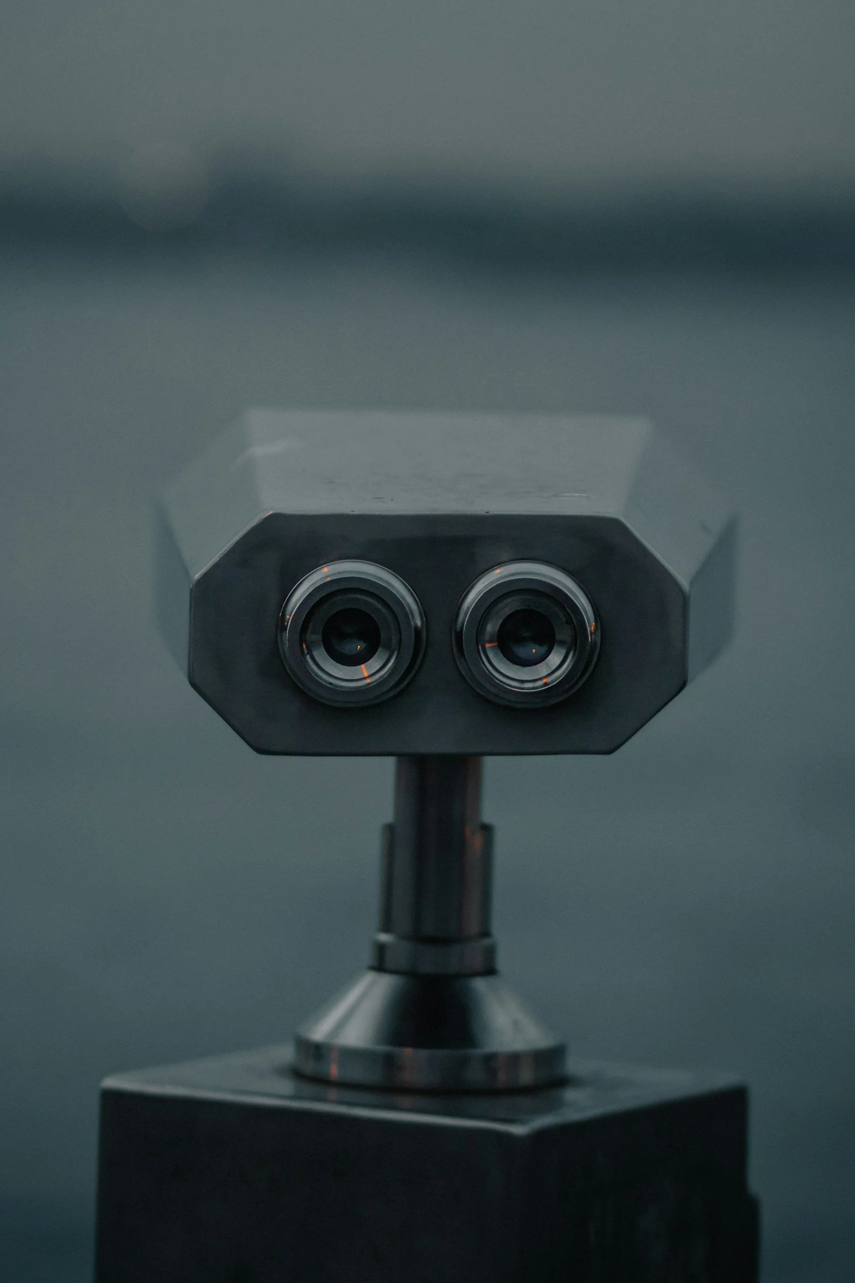 A metallic scientific instrument with two circular openings, mounted on a stand with a dashboard and a dark background.