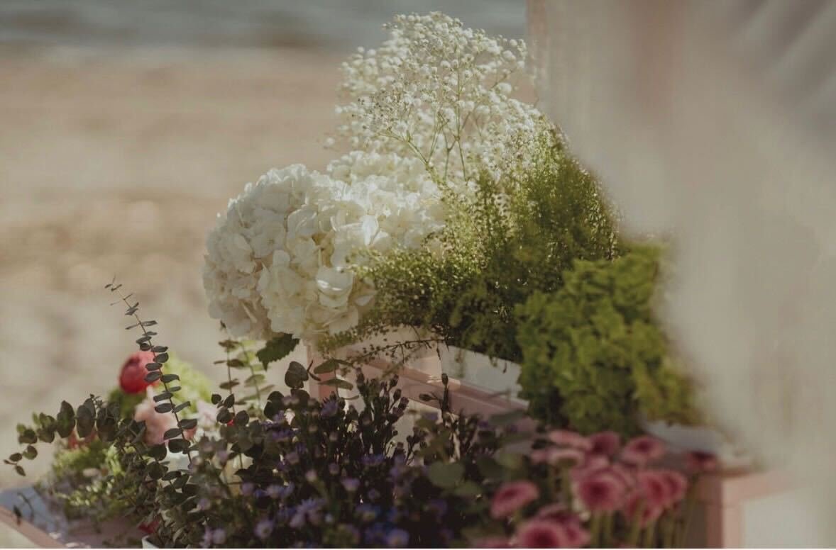 A bouquet of white hydrangeas, pink roses, and greenery in a soft, blurry setting.